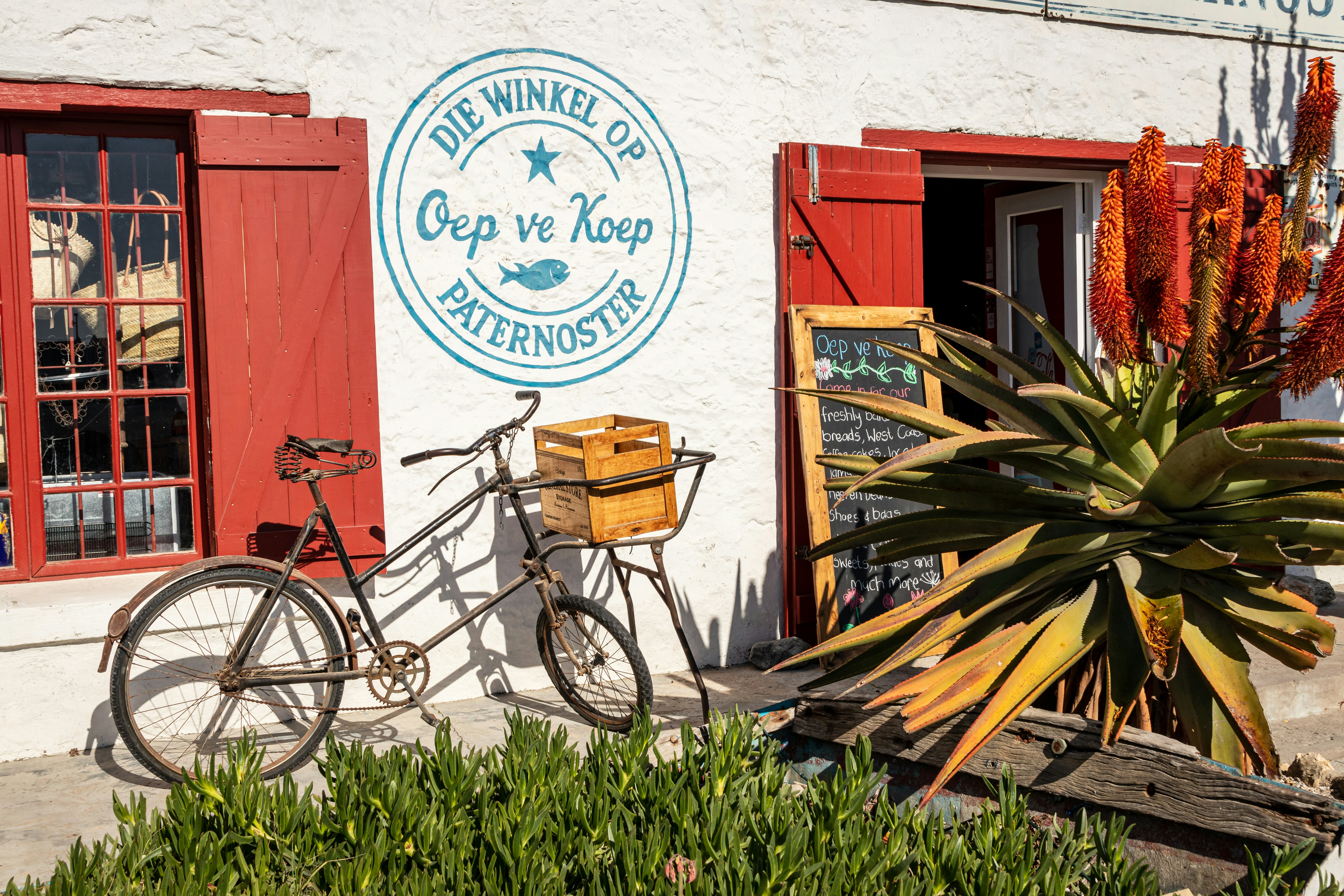 A bike parked outside of a building with red shutters
