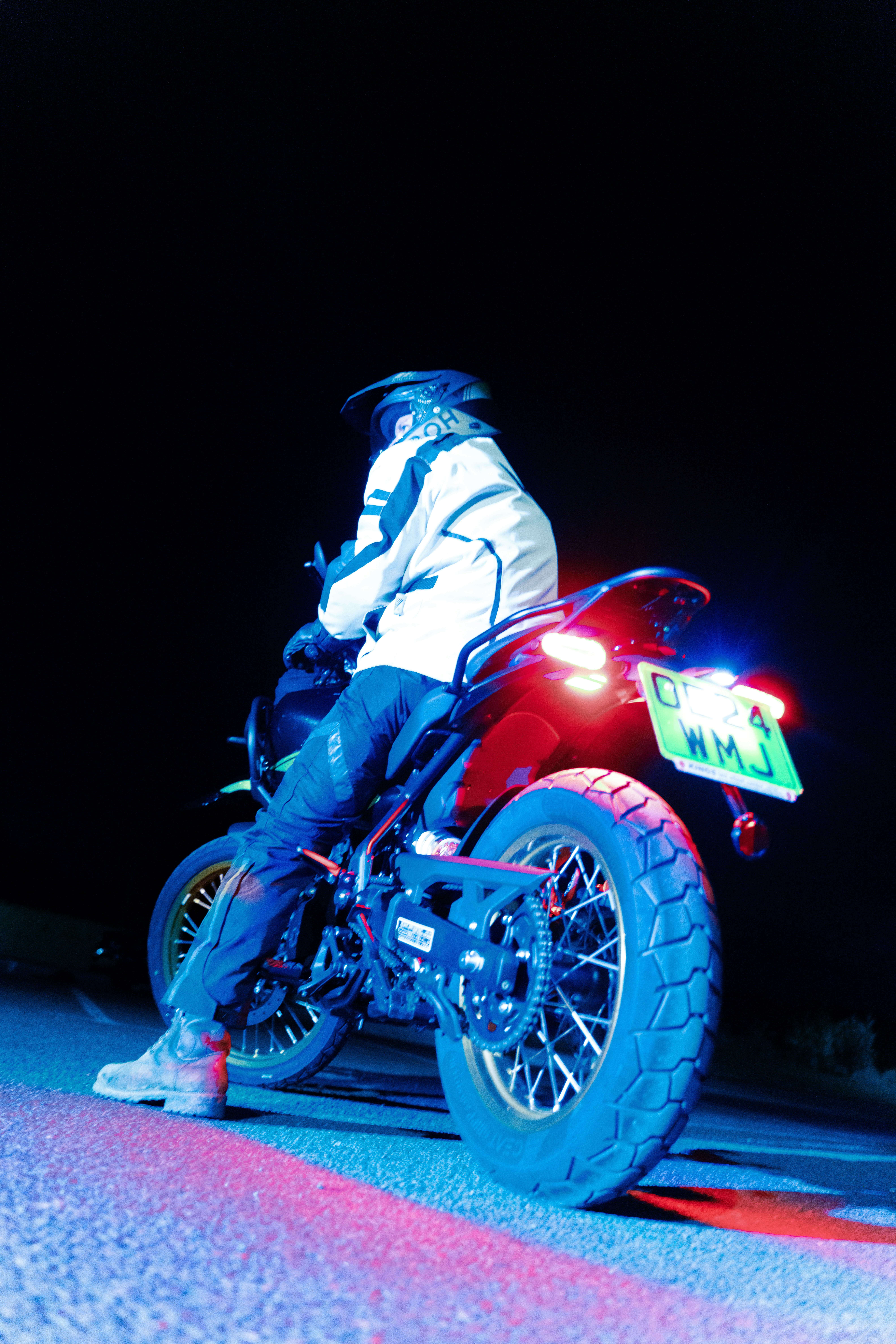 A person riding a motorcycle on a road at night