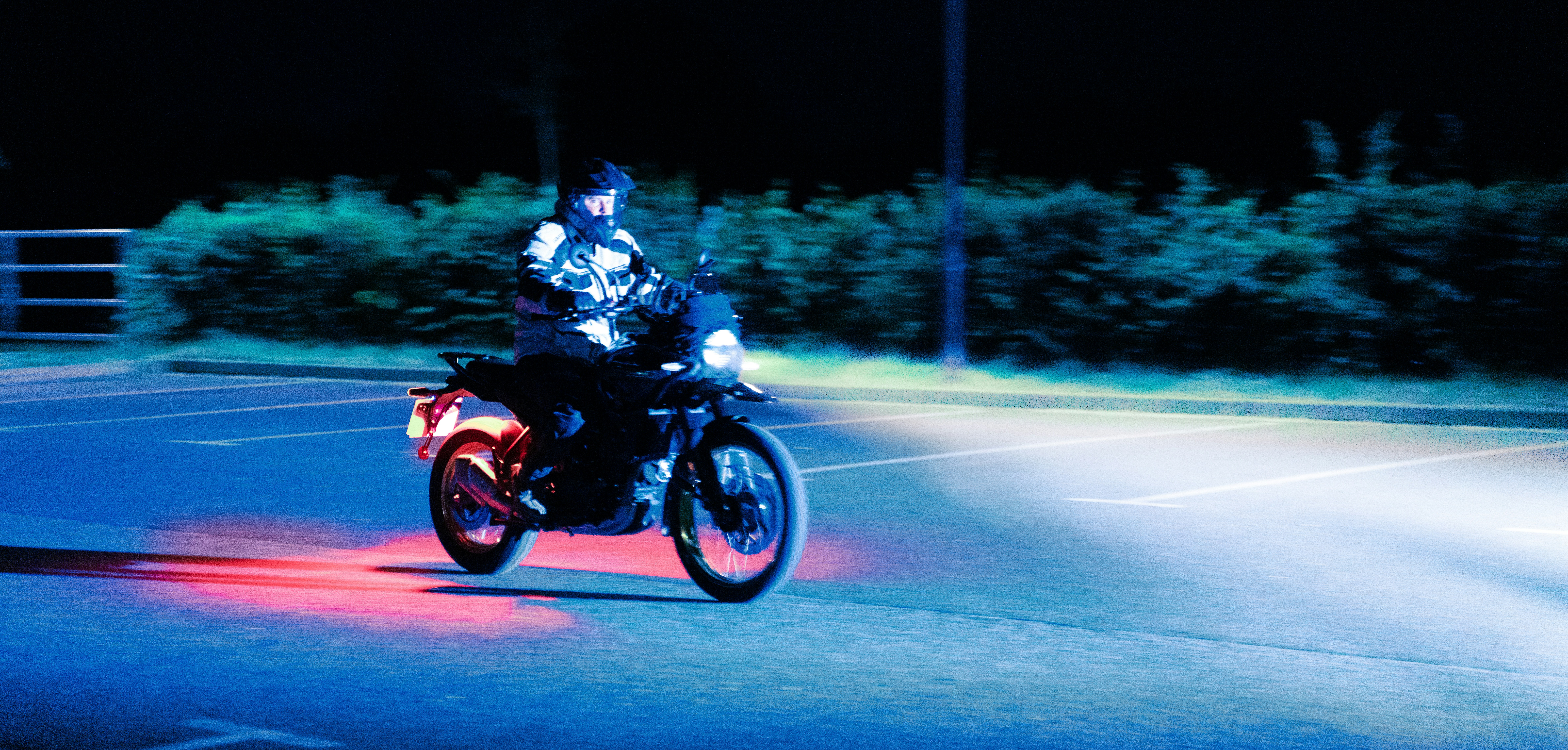 A man riding a motorcycle down a street at night