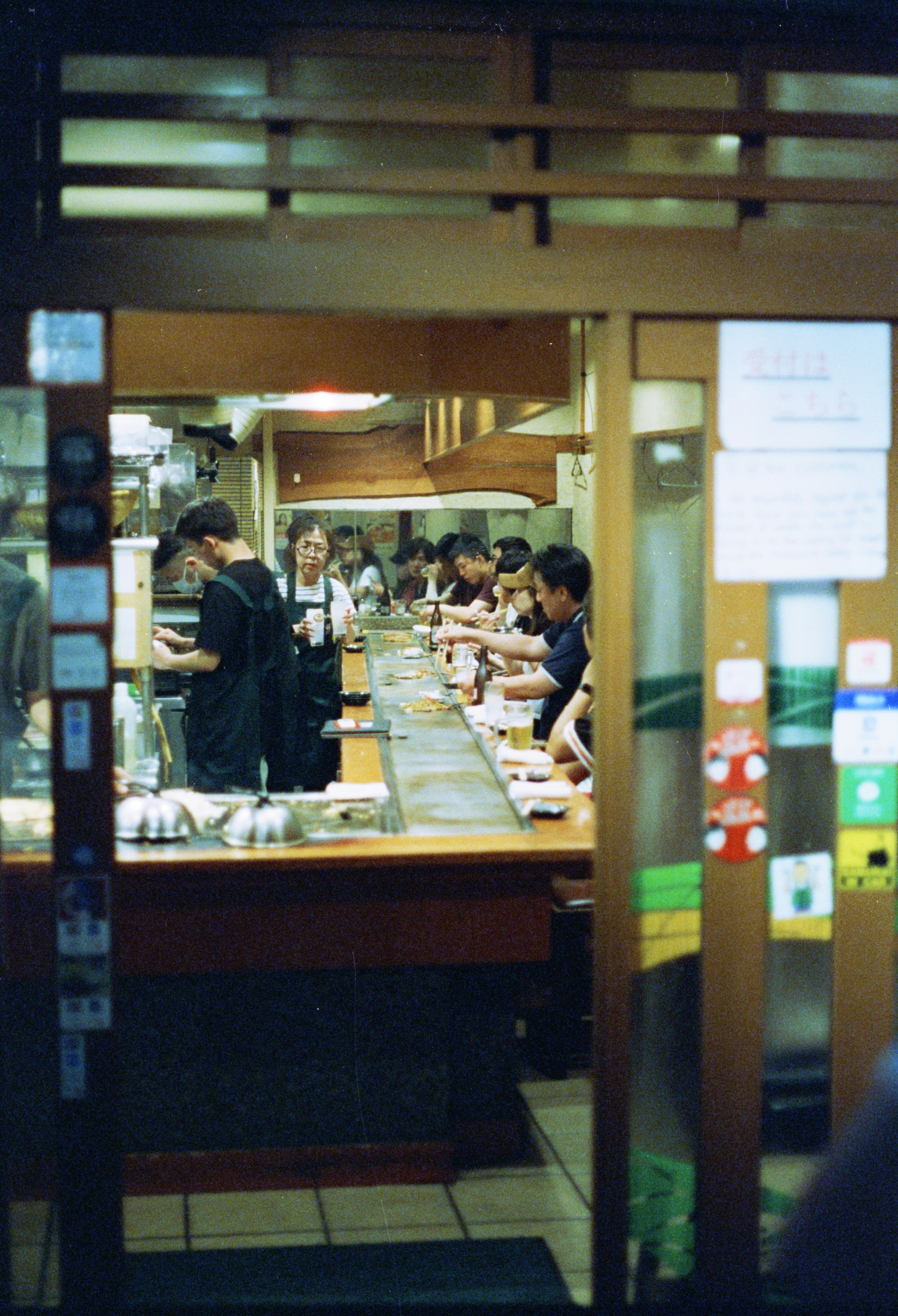 A group of people standing in a kitchen preparing food