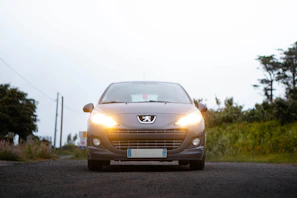 A silver car driving down a rural road