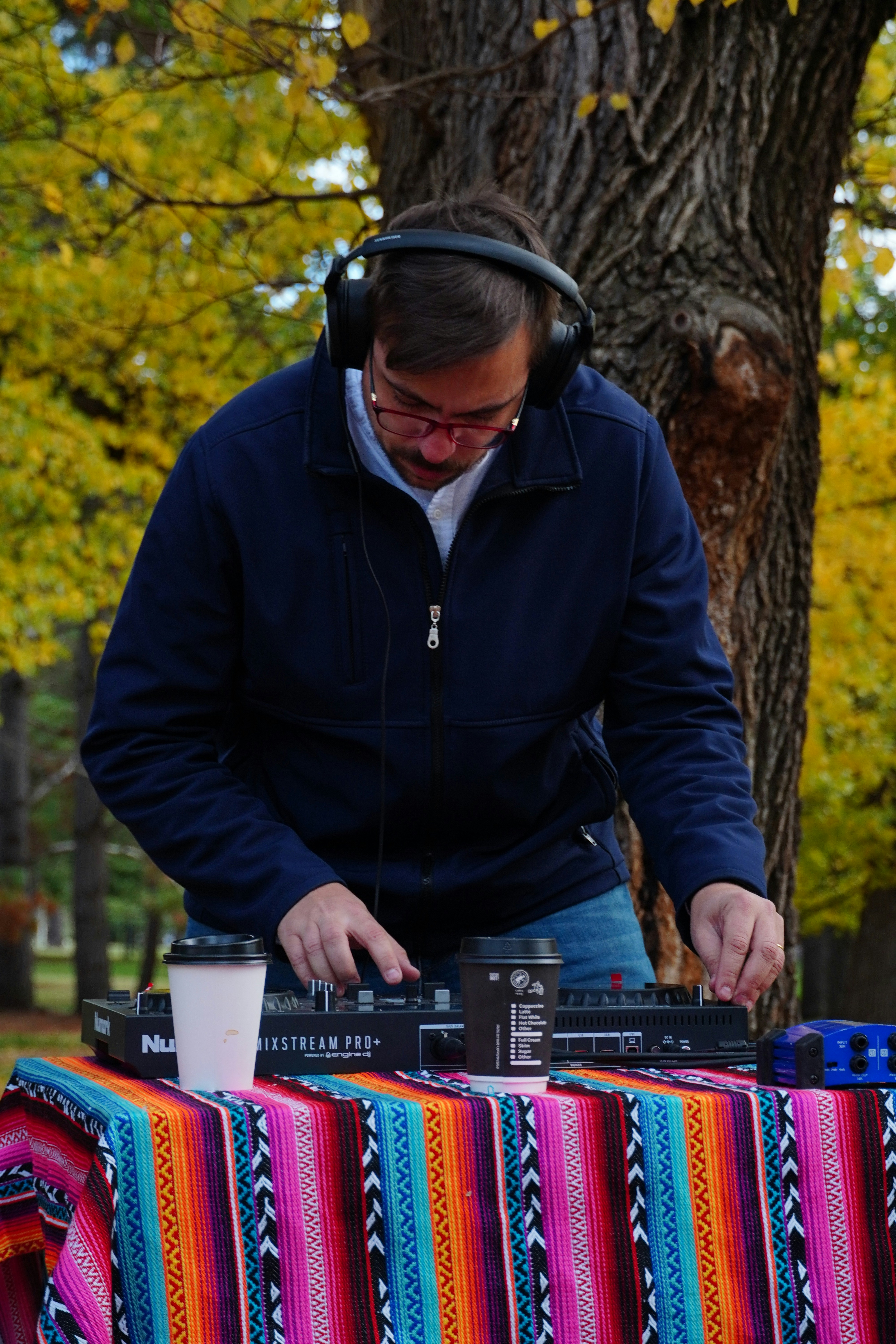 A man wearing headphones standing next to a table