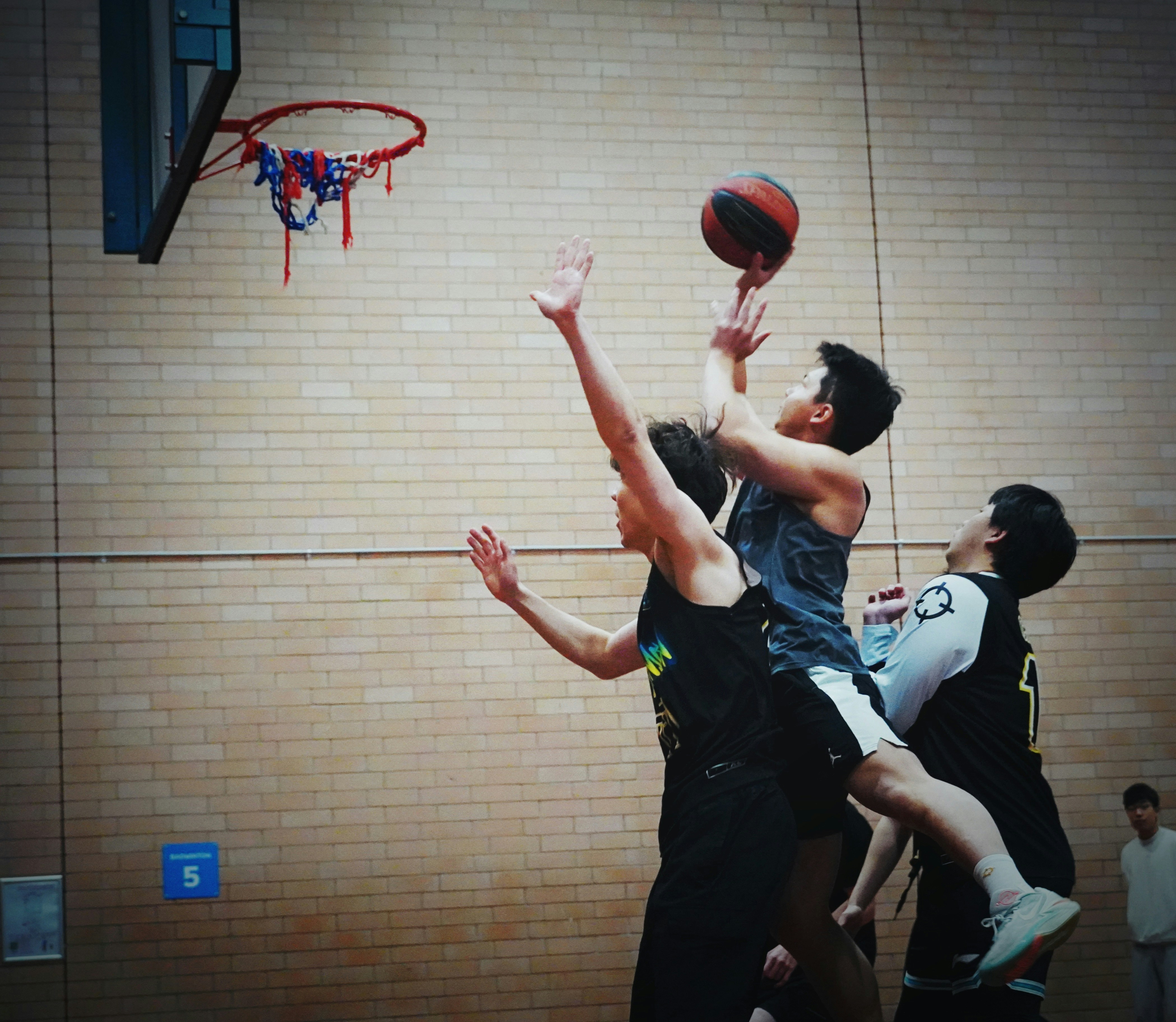 A group of young men playing a game of basketball