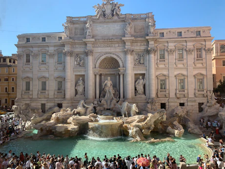 A crowd of people standing around a fountain
