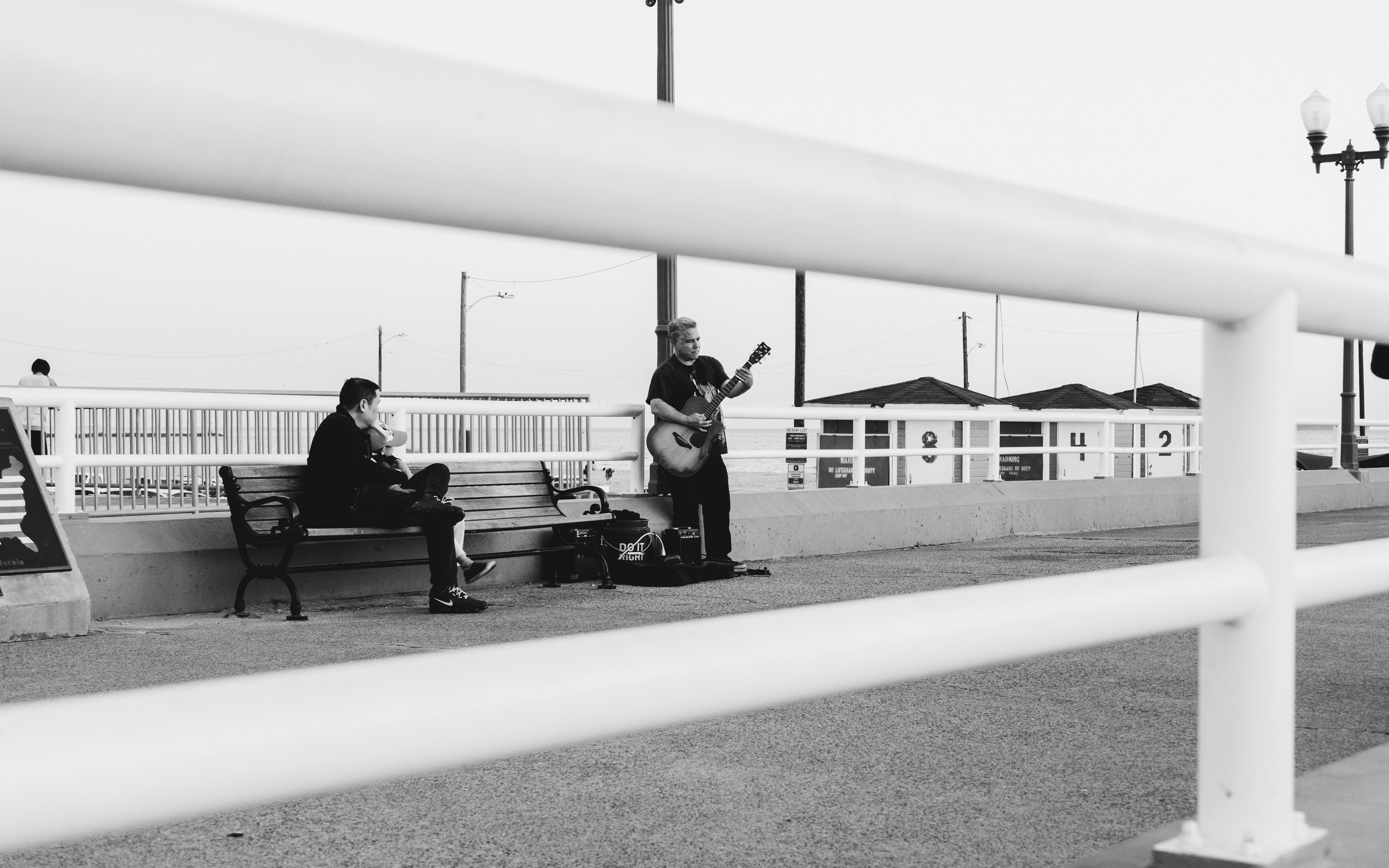 A black and white photo of people sitting on benches