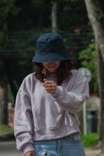 A woman in a blue hat is looking at her cell phone