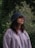 A woman standing in front of a tree with a frisbee in her hand