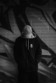 A man standing in front of a graffiti wall