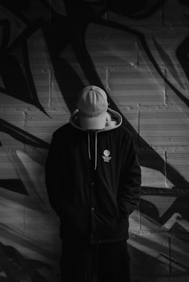 A man standing in front of a graffiti wall