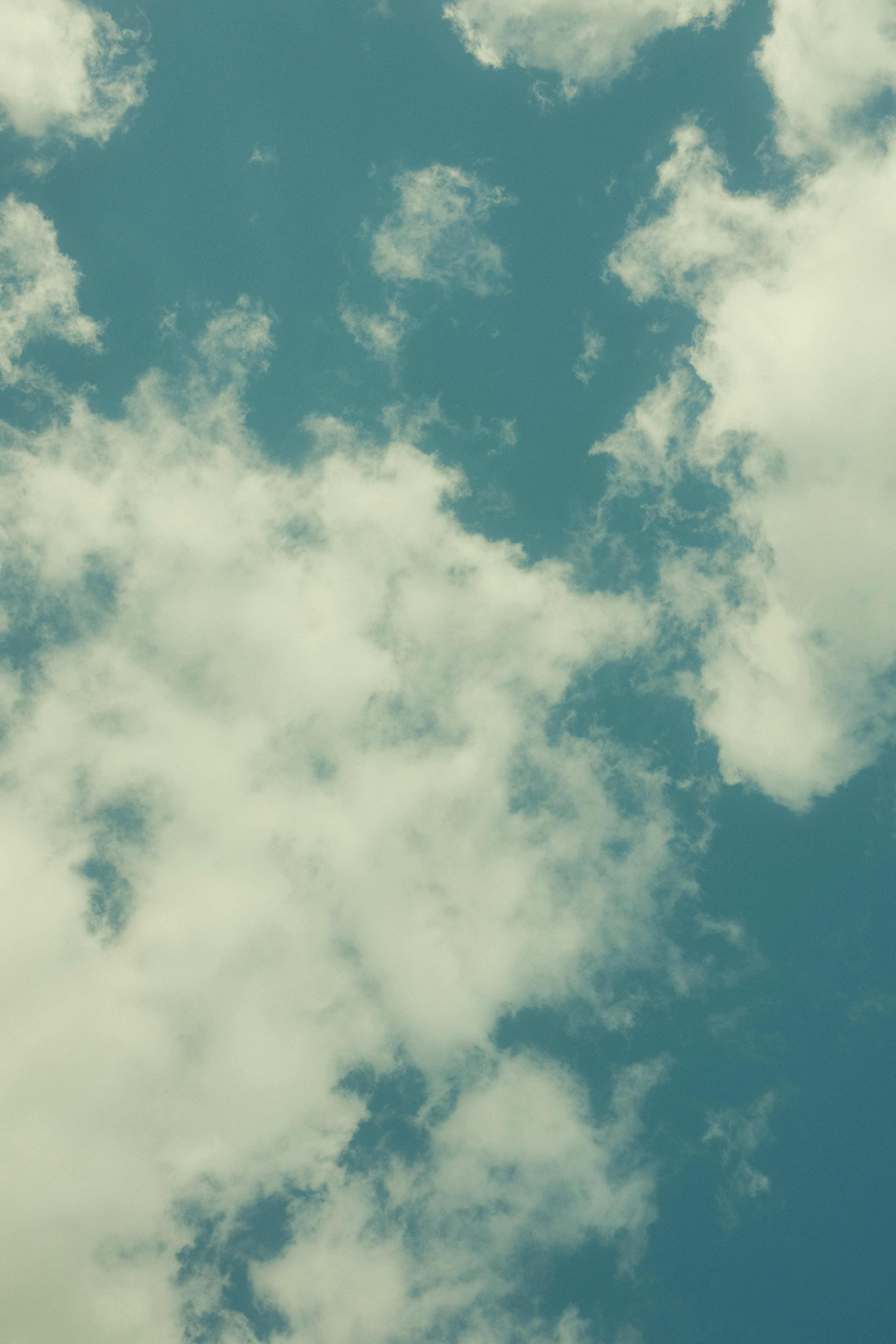 A plane flying through a cloudy blue sky