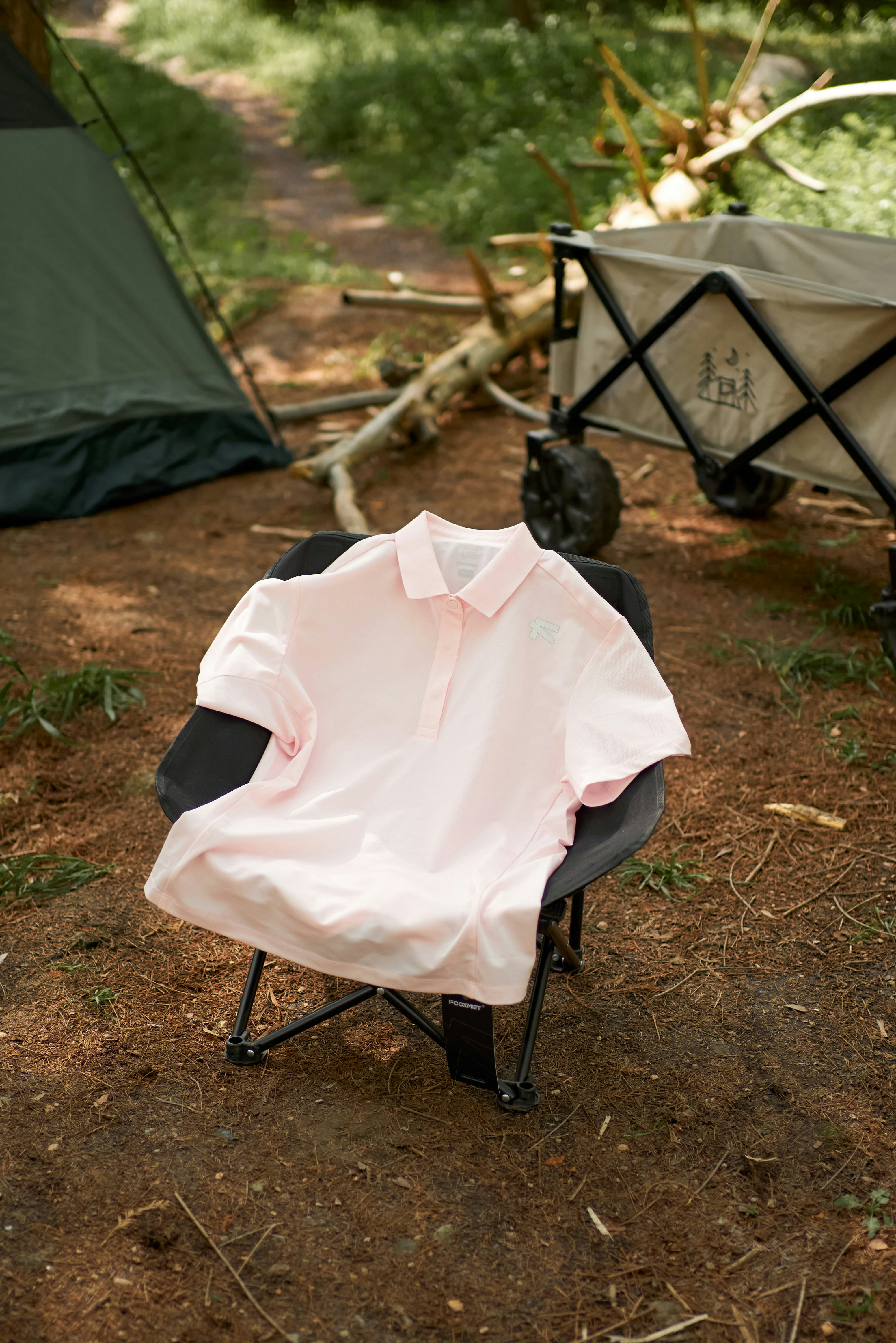 A pink shirt sitting on top of a folding chair