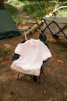 A pink shirt sitting on top of a folding chair