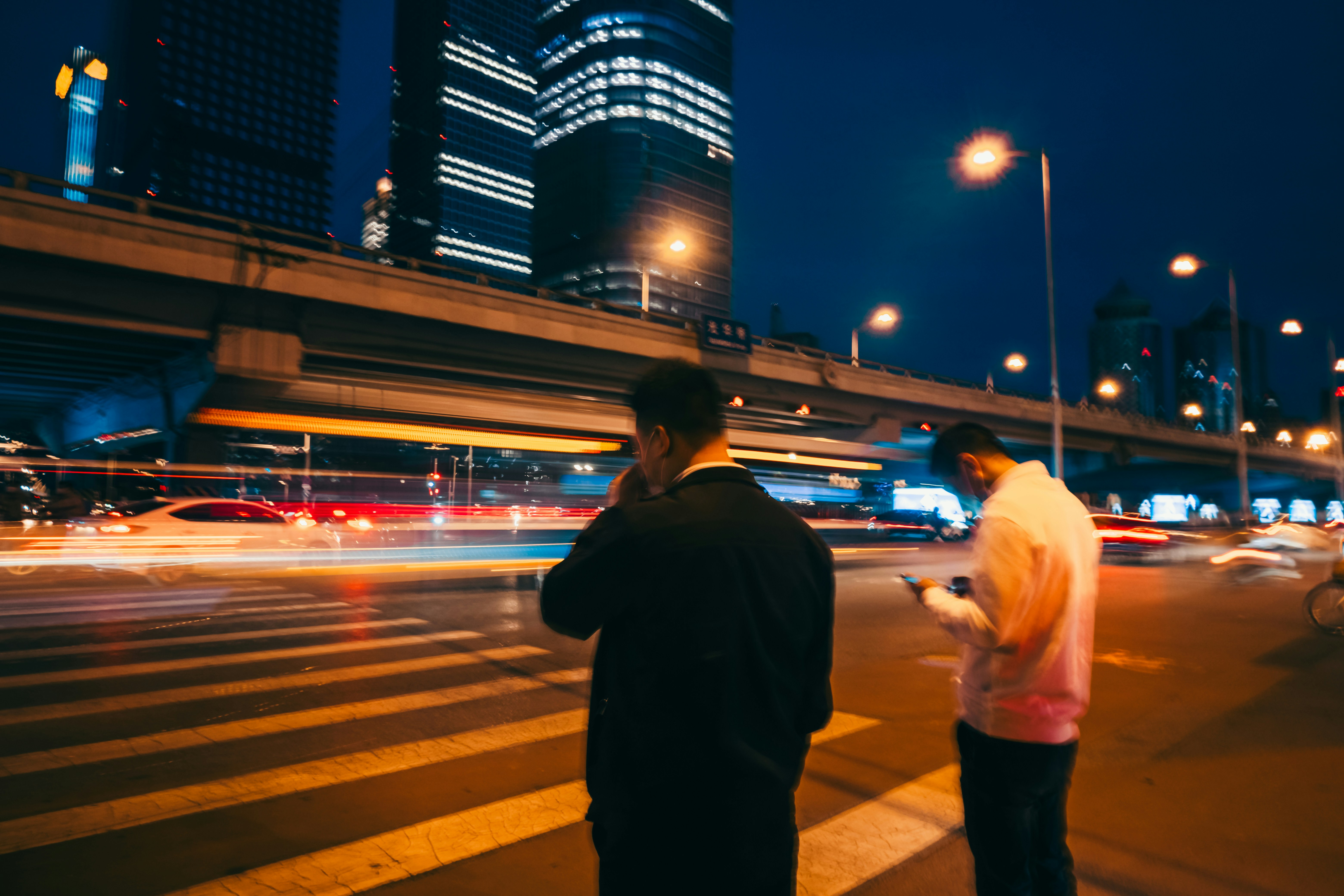 A couple of people standing on the side of a road