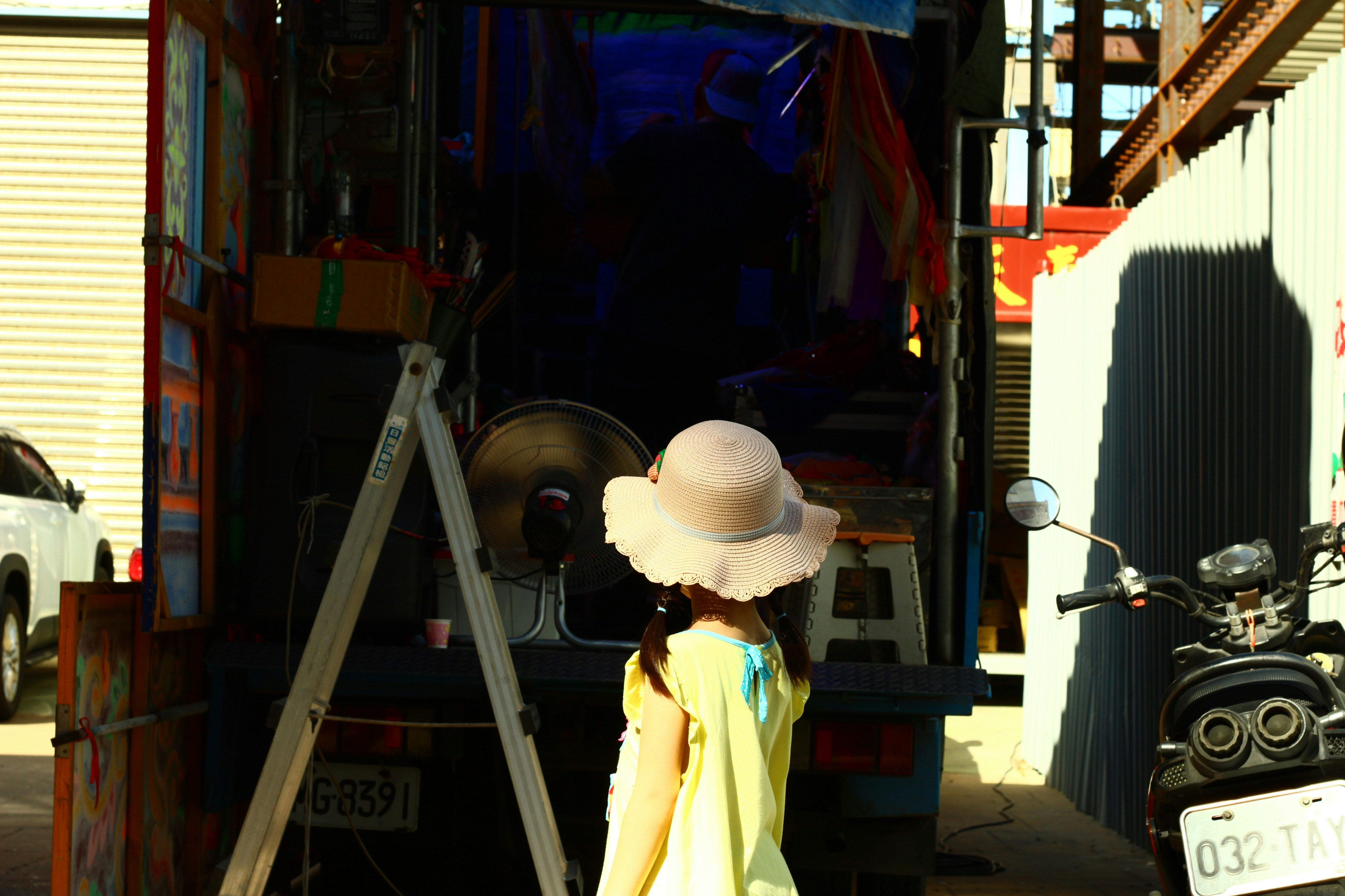 A woman in a yellow dress and a white hat