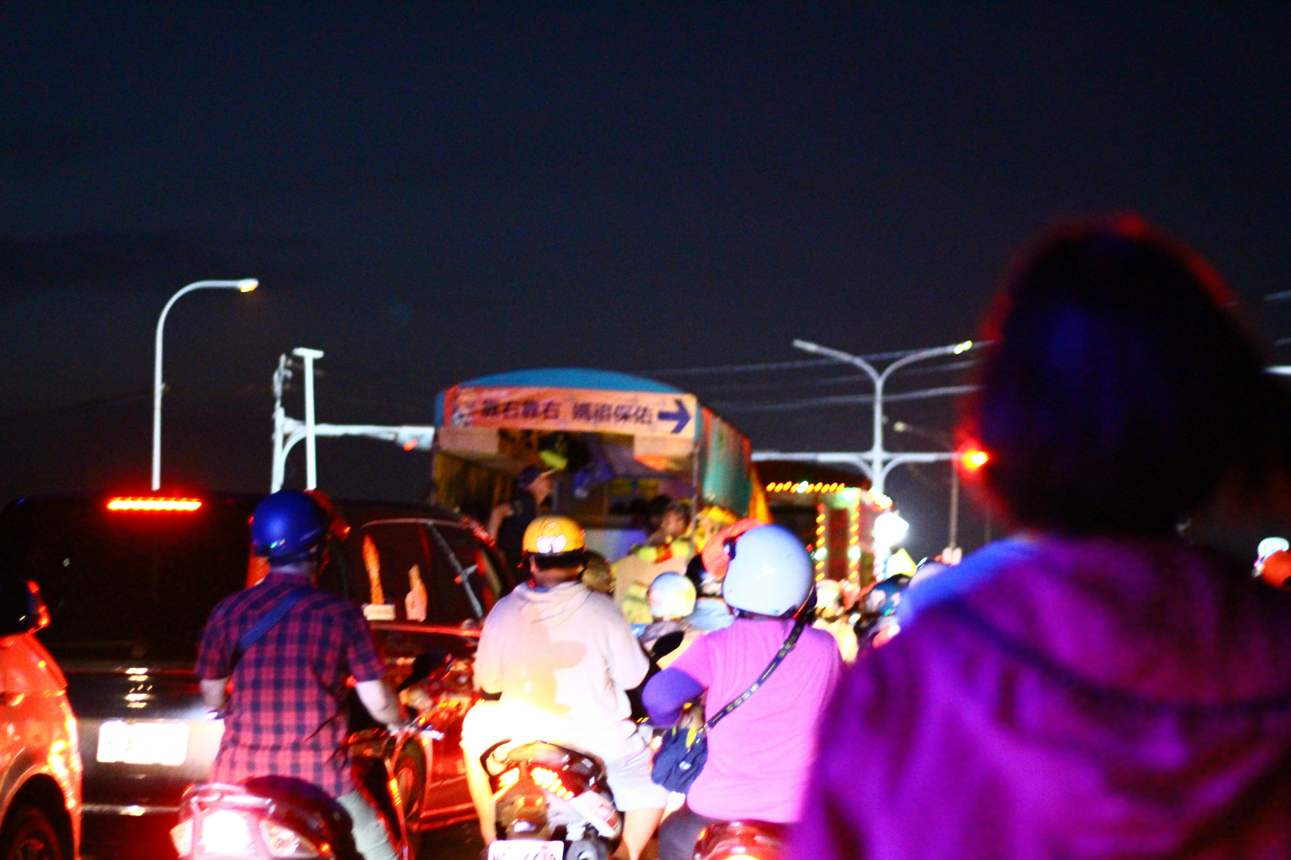 A group of people riding motorcycles down a street