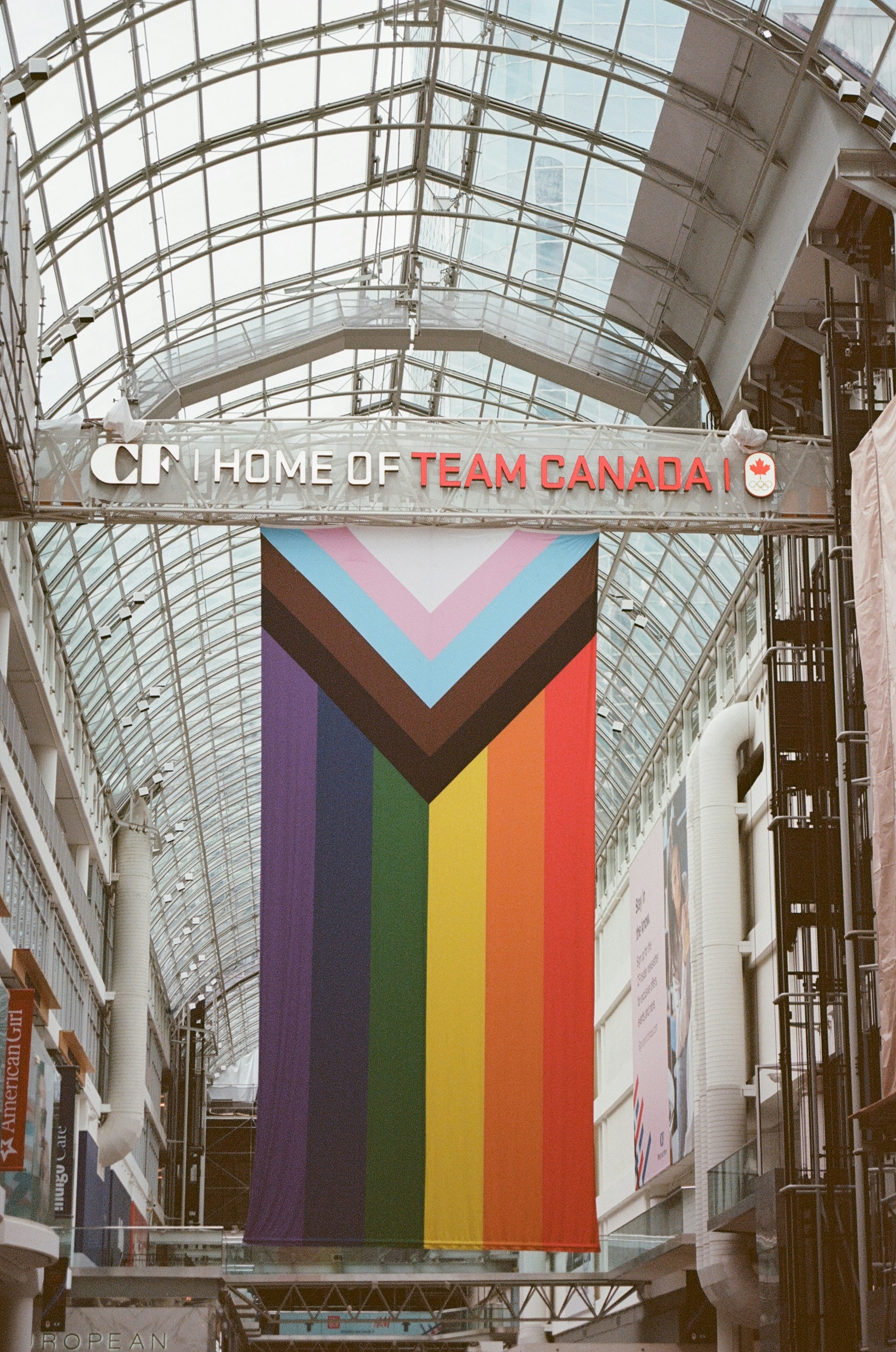 A rainbow banner hanging from the ceiling of a building