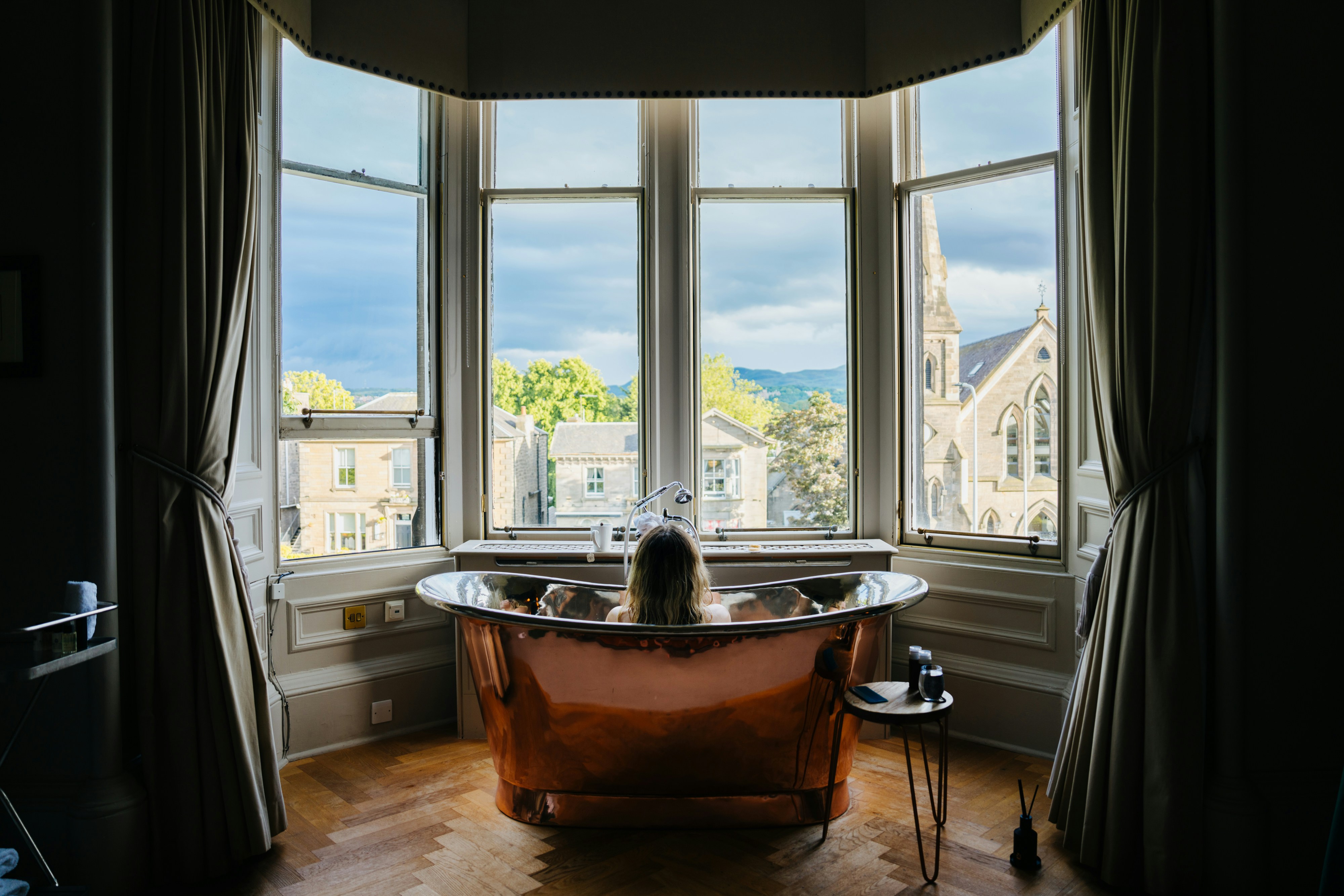 Eine Badewanne, die in einem Badezimmer neben einem Fenster sitzt