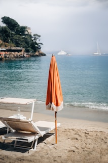 An umbrella and chair on a beach near the ocean