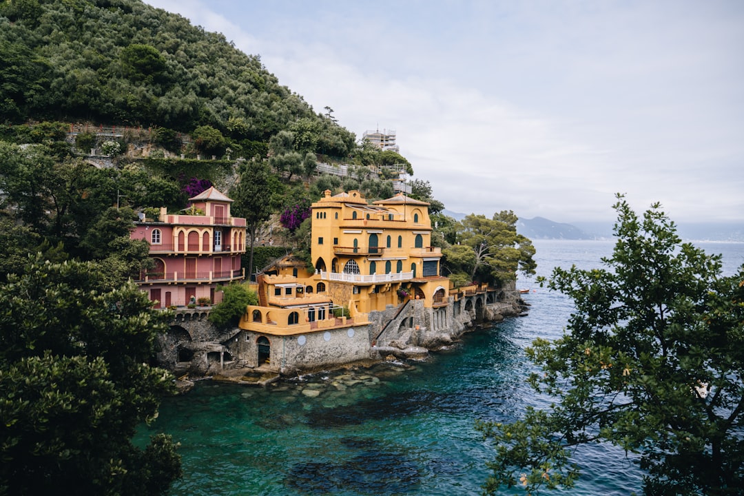 A group of buildings sitting on top of a cliff next to the ocean,