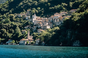 A small village on the side of a mountain next to a body of water