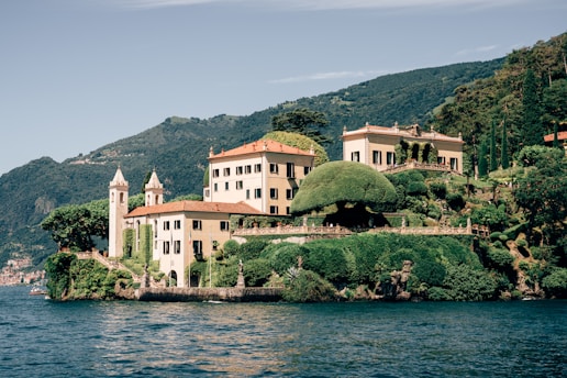A large white building sitting on top of a lush green hillside