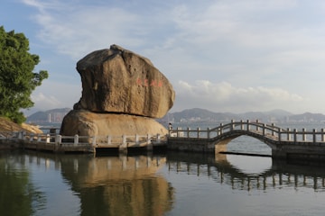 A large rock sitting on top of a body of water