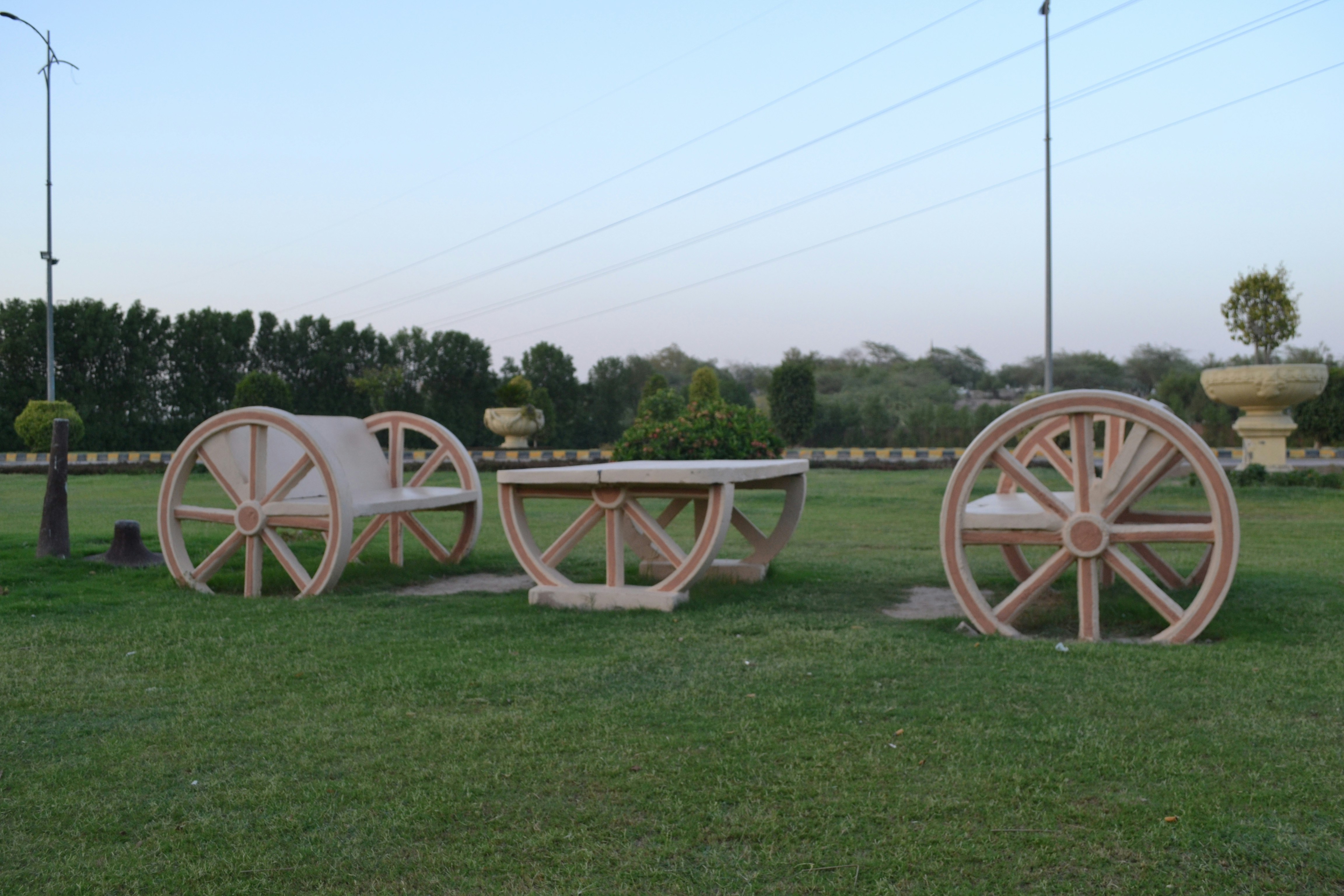 A row of wooden wagon wheels sitting on top of a lush green field