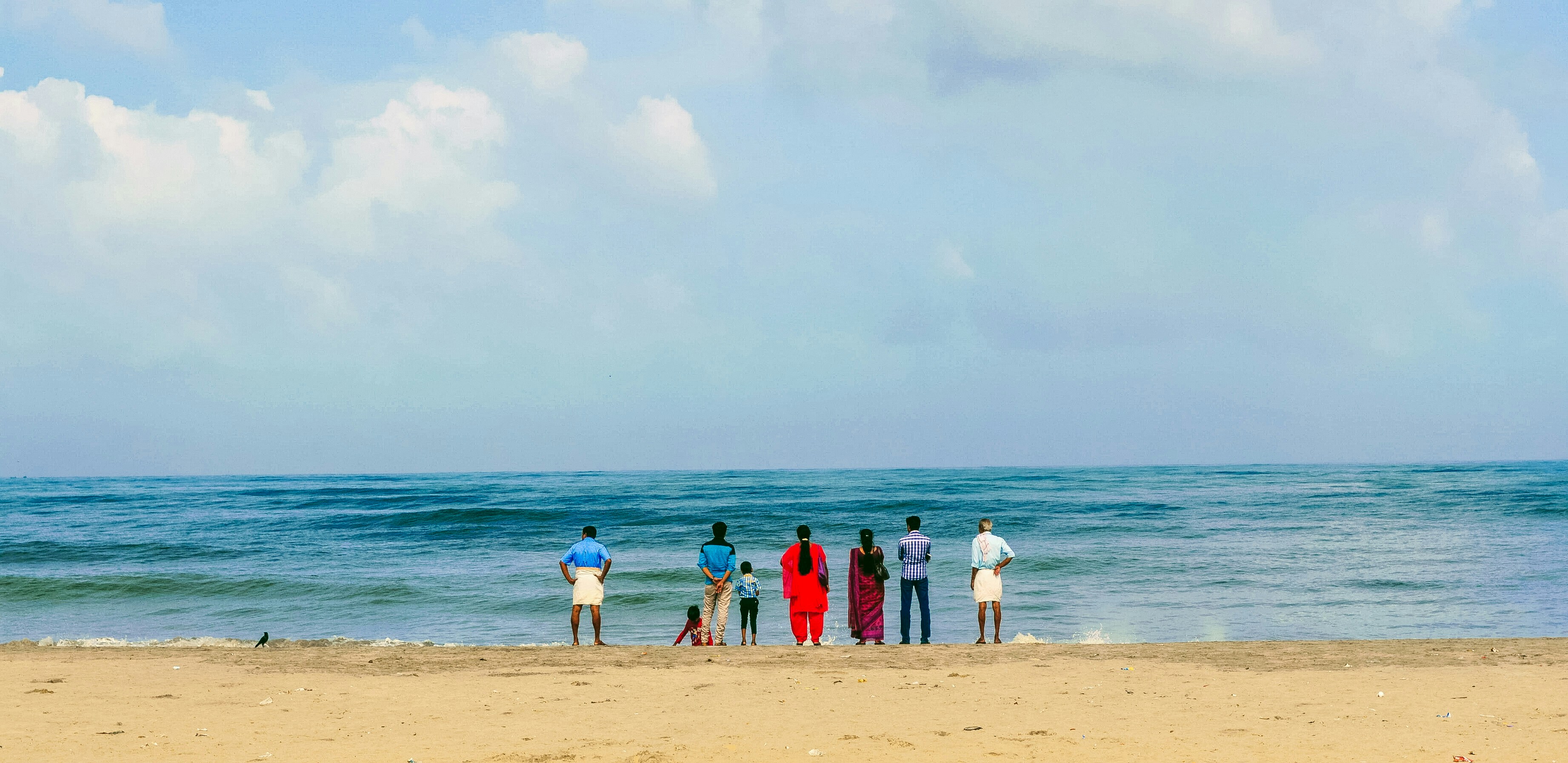 A group of people standing on top of a sandy beach
