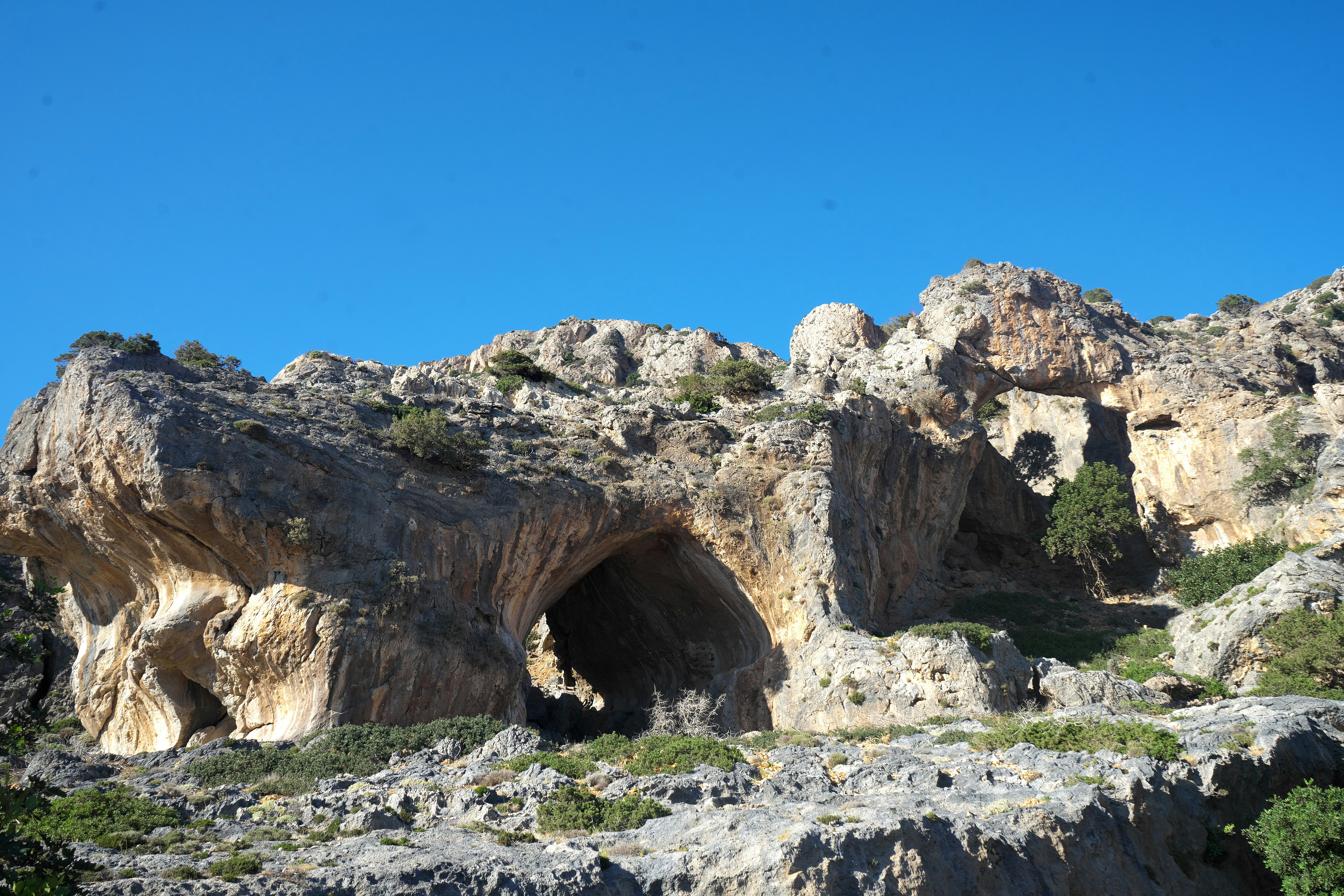 A large rock formation with a cave in the middle of it