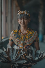 A woman in a colorful dress holding a fan