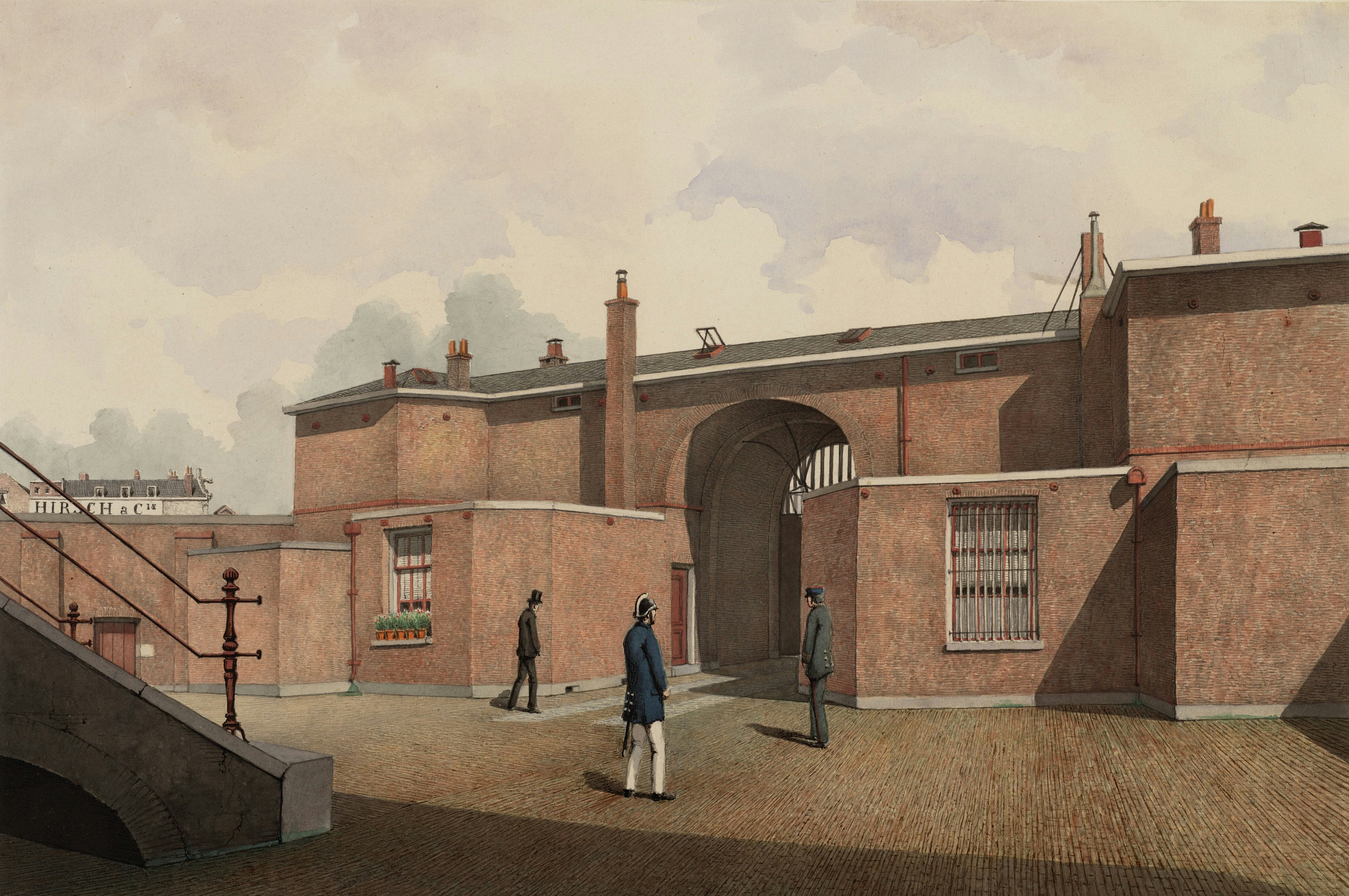 People walk through a brick courtyard with arched entrance.