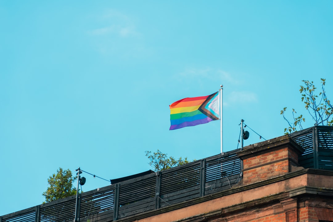A rainbow flag flying on top of a building,