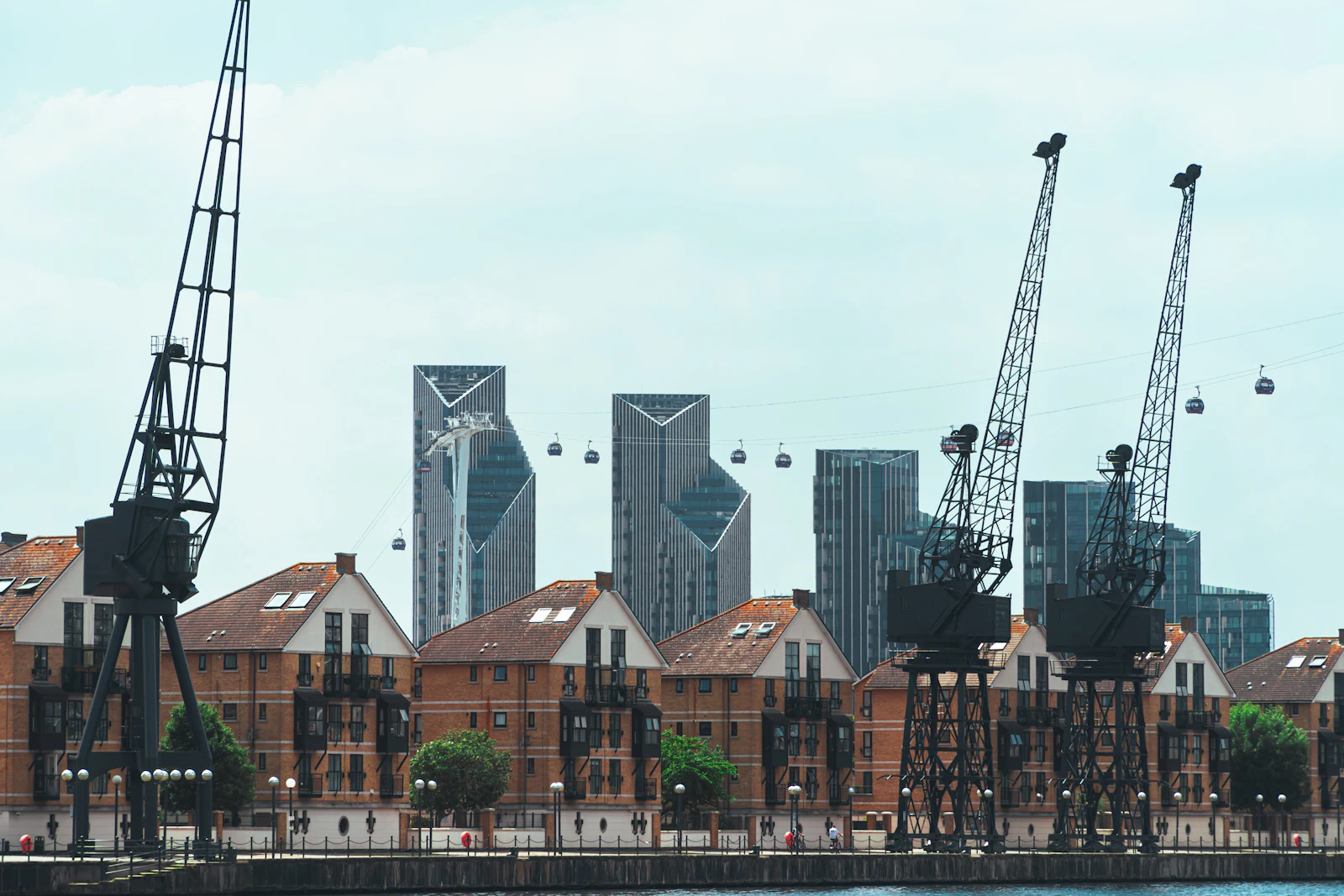 Historic dockside cranes on Royal Victoria Dock with Canary Wharf behind