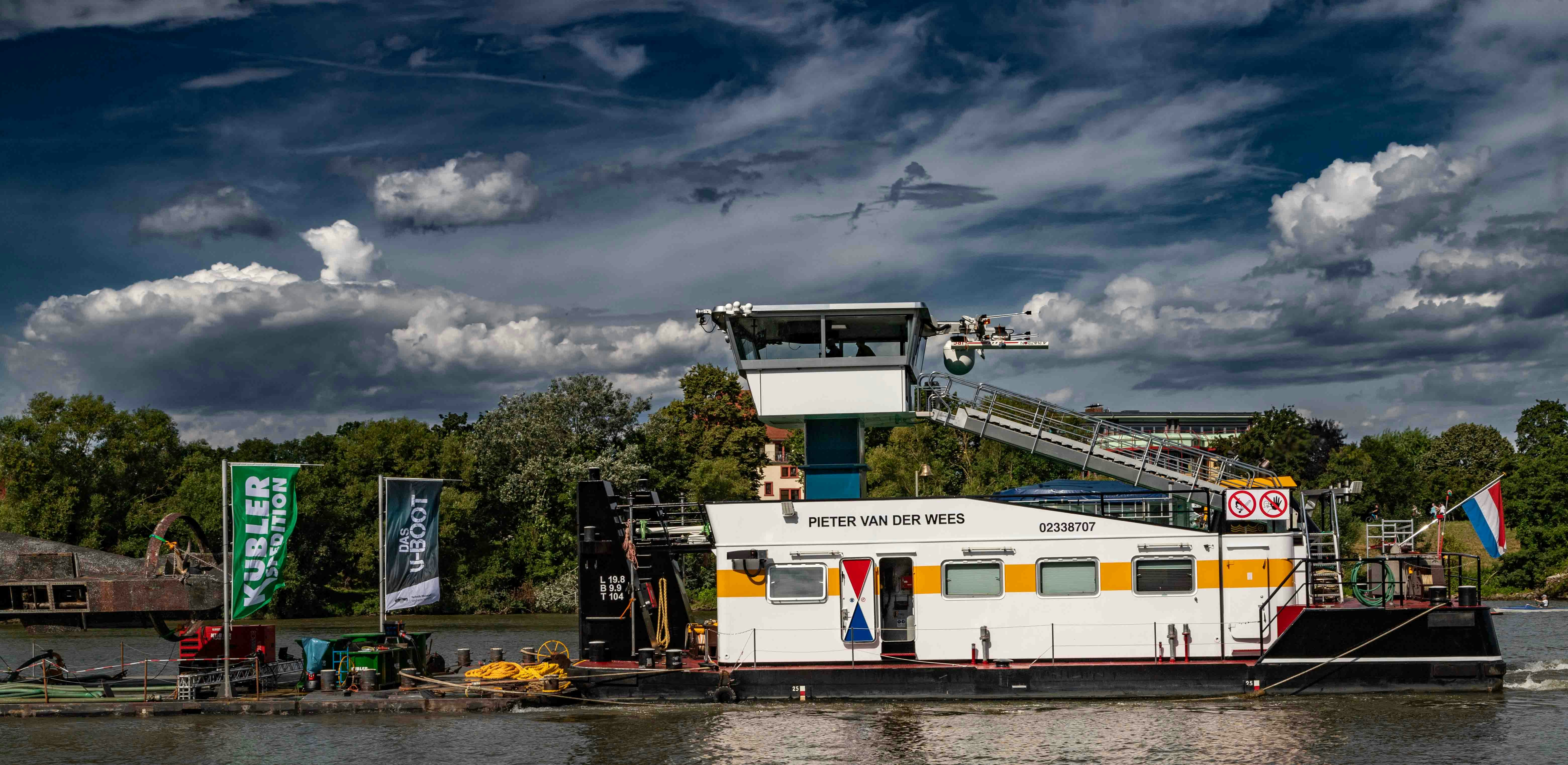 A large white boat floating on top of a river