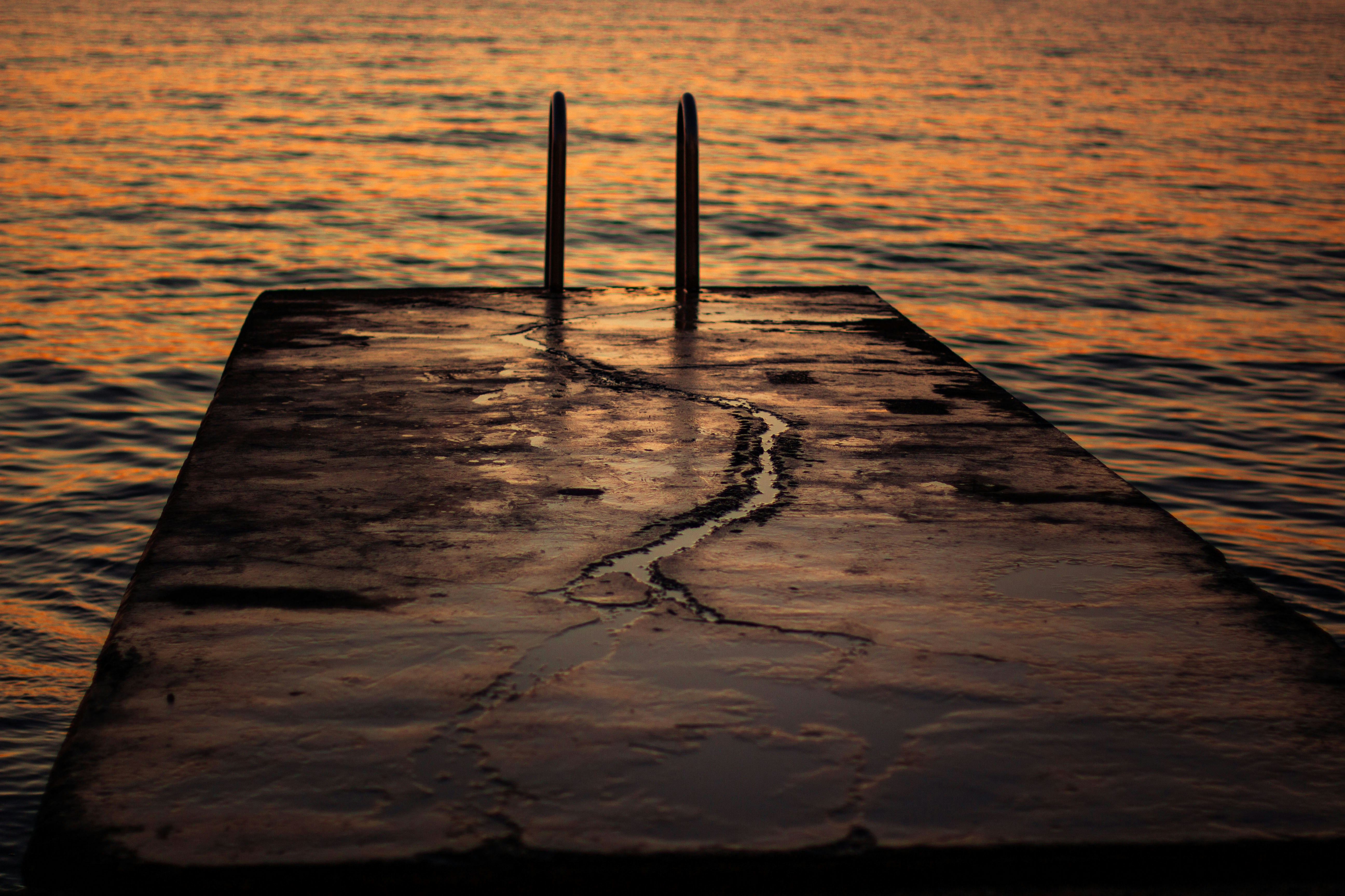 A long dock with two poles sticking out of the water