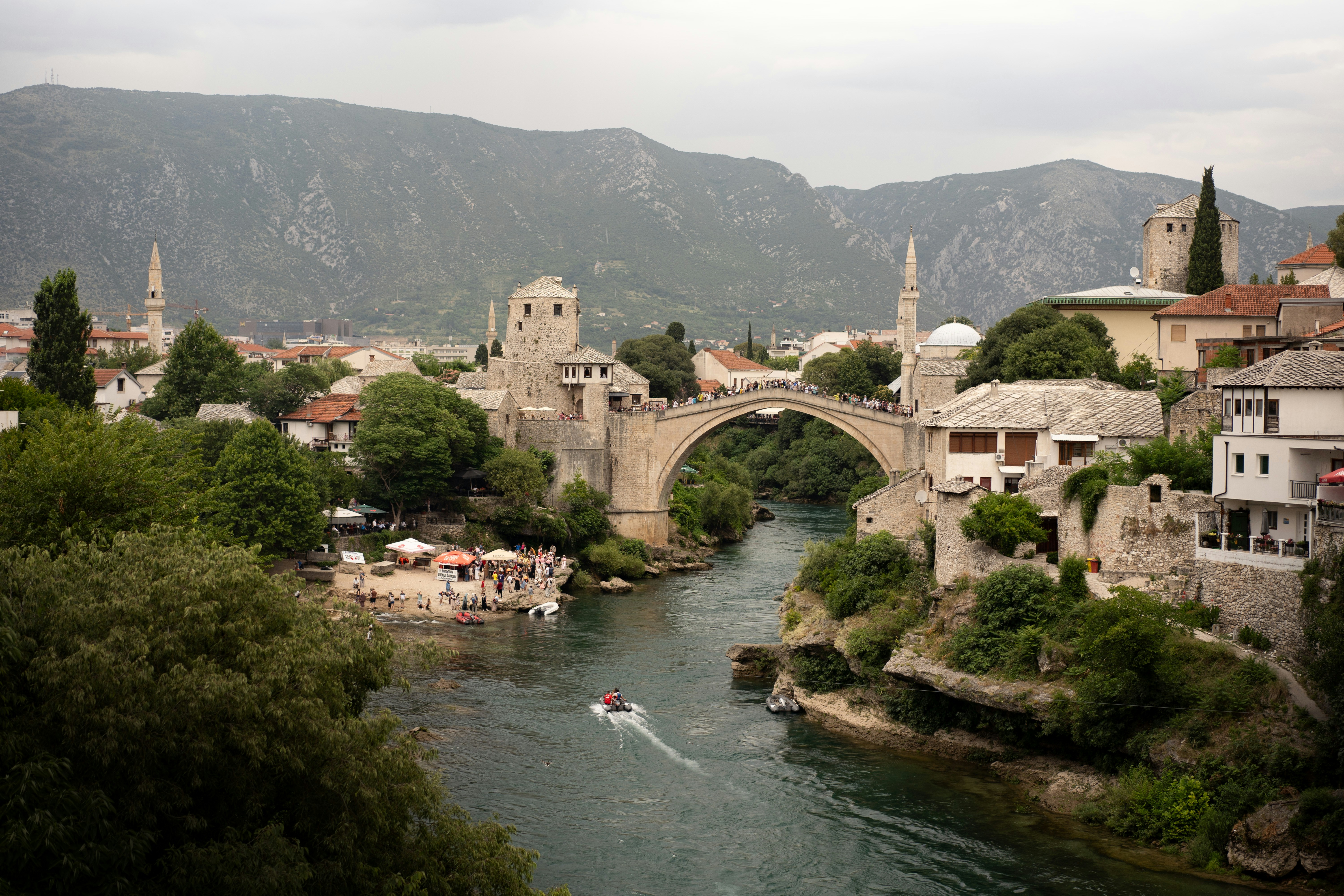 A river flowing under a bridge next to a town