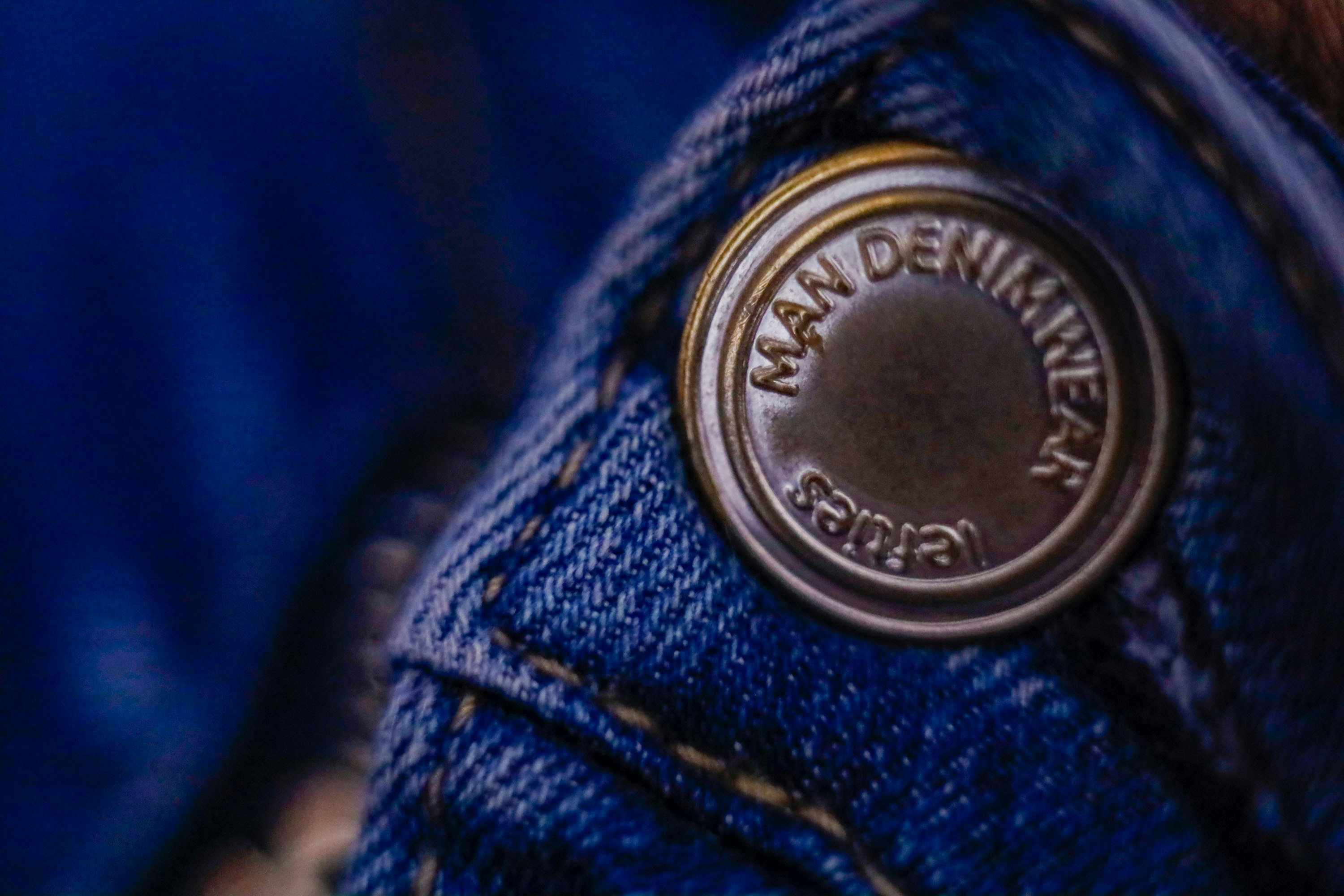 A close up of a button on a pair of jeans
