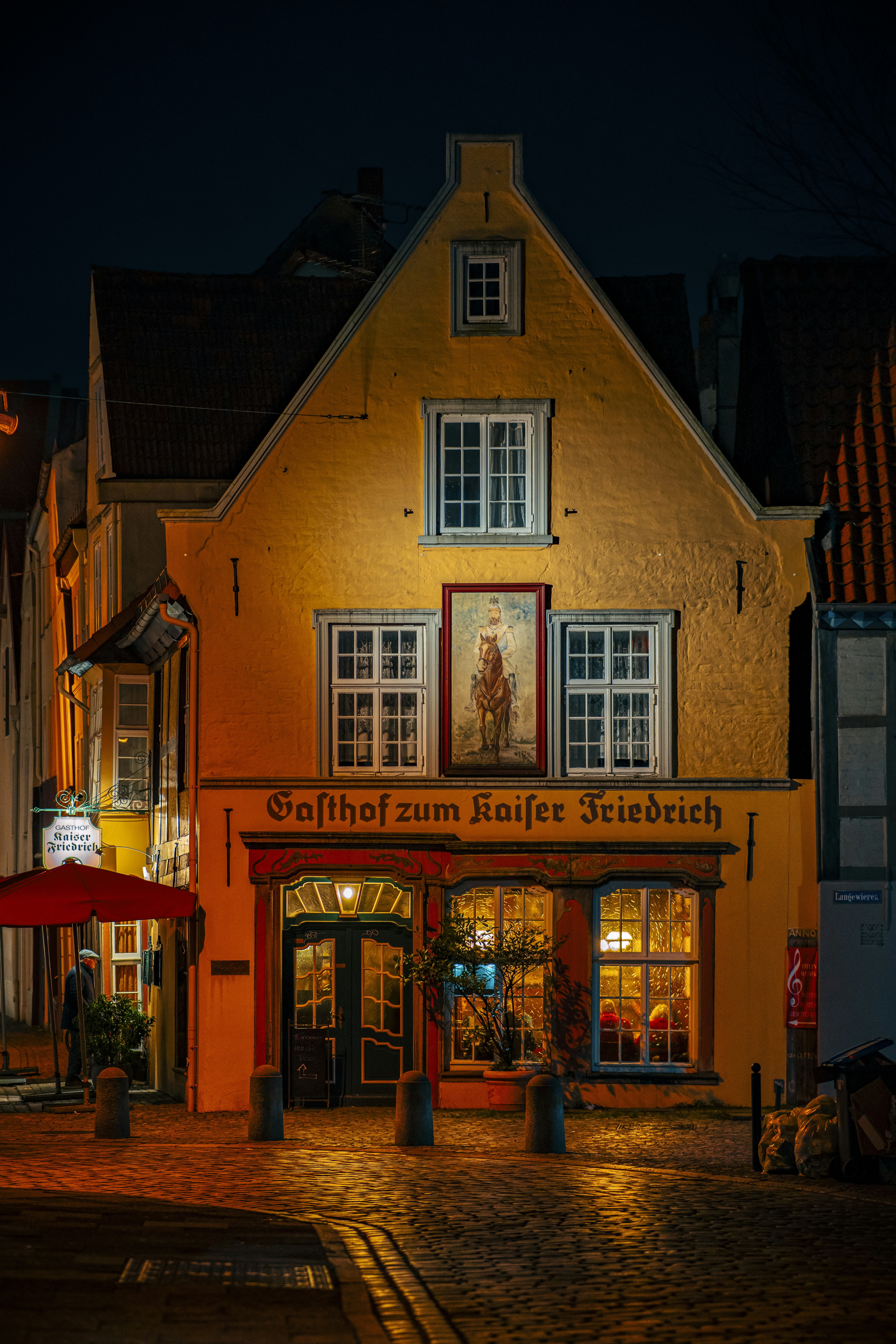 Ein Gebäude mit roter Markise auf einer Kopfsteinpflasterstraße