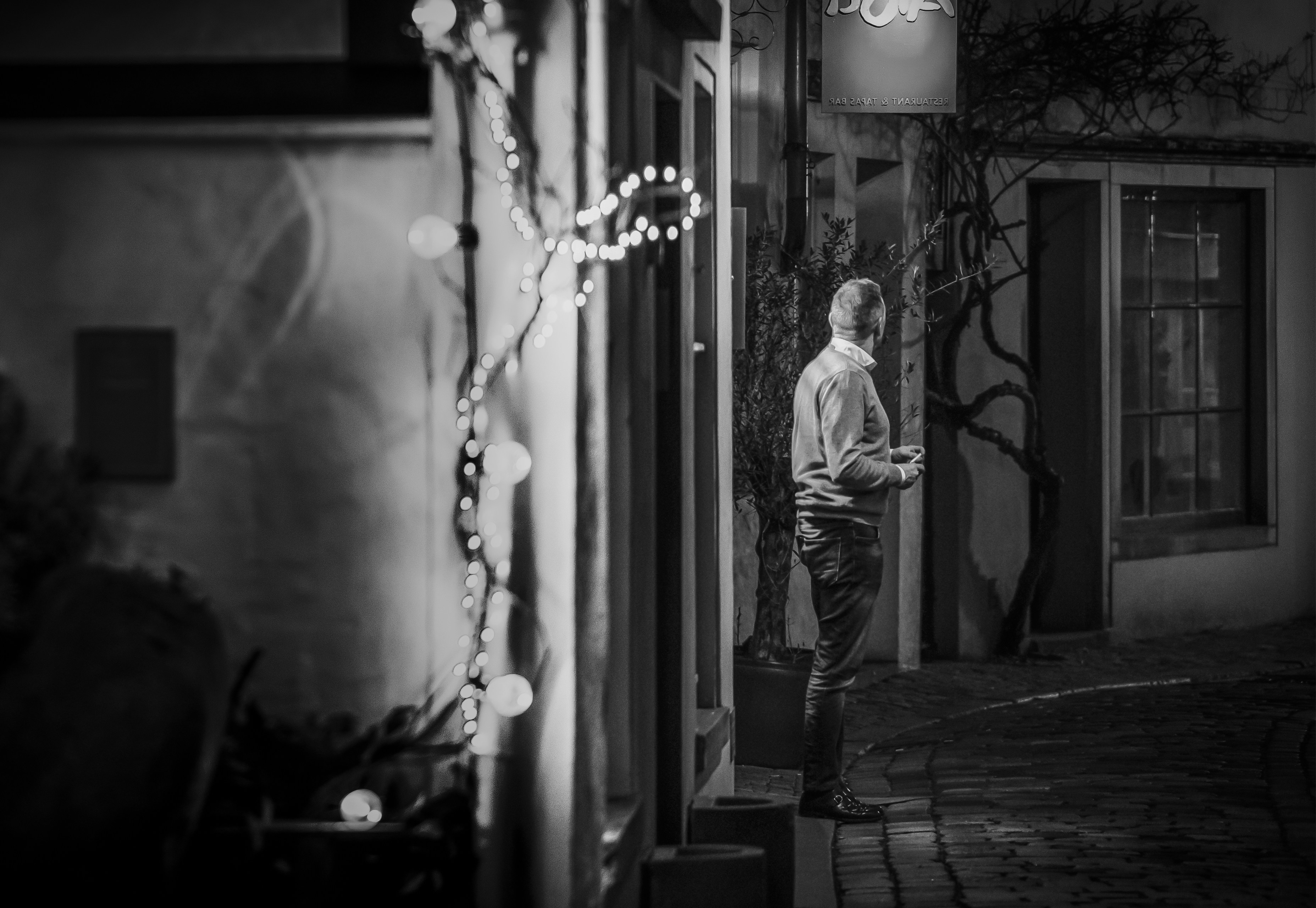 A man standing outside of a building at night photo – Free Grey Image ...
