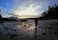 A person walking on a beach at sunset