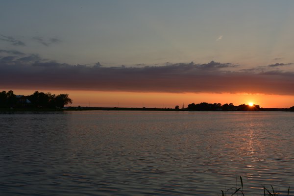 The sun is setting over a body of water — Haapsalu, Estonia