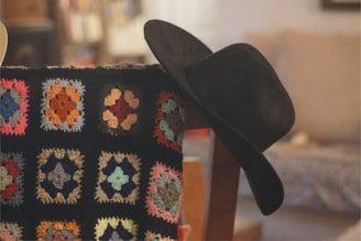 A black hat sitting on top of a chair