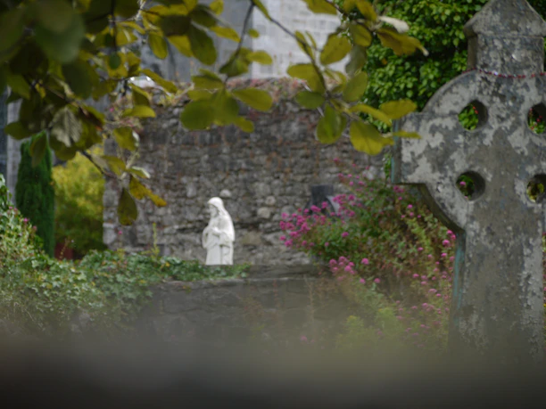A cemetery with a white statue in the foreground
