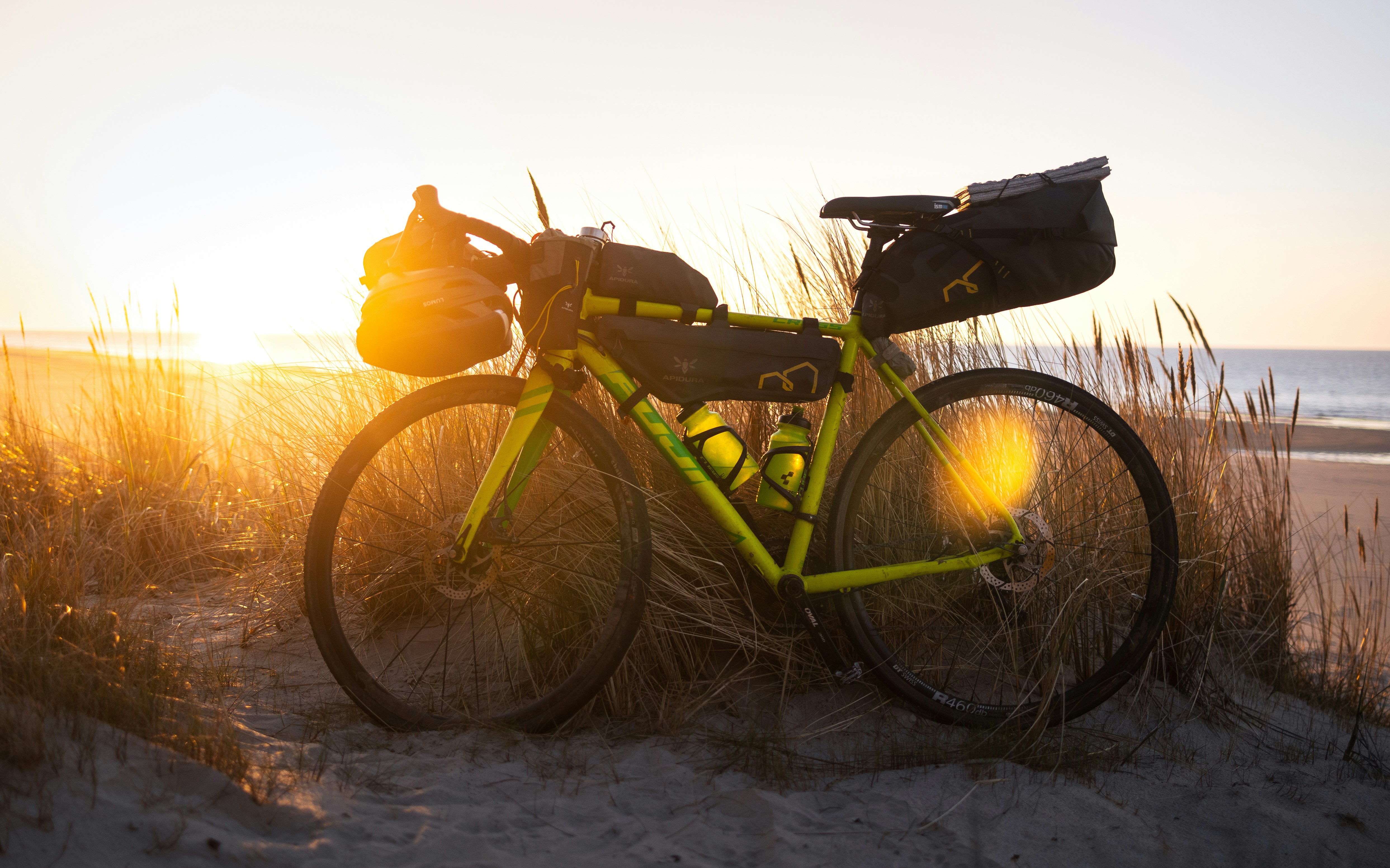A bike parked on a beach next to the ocean