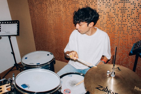 A young man sitting in front of a drum set