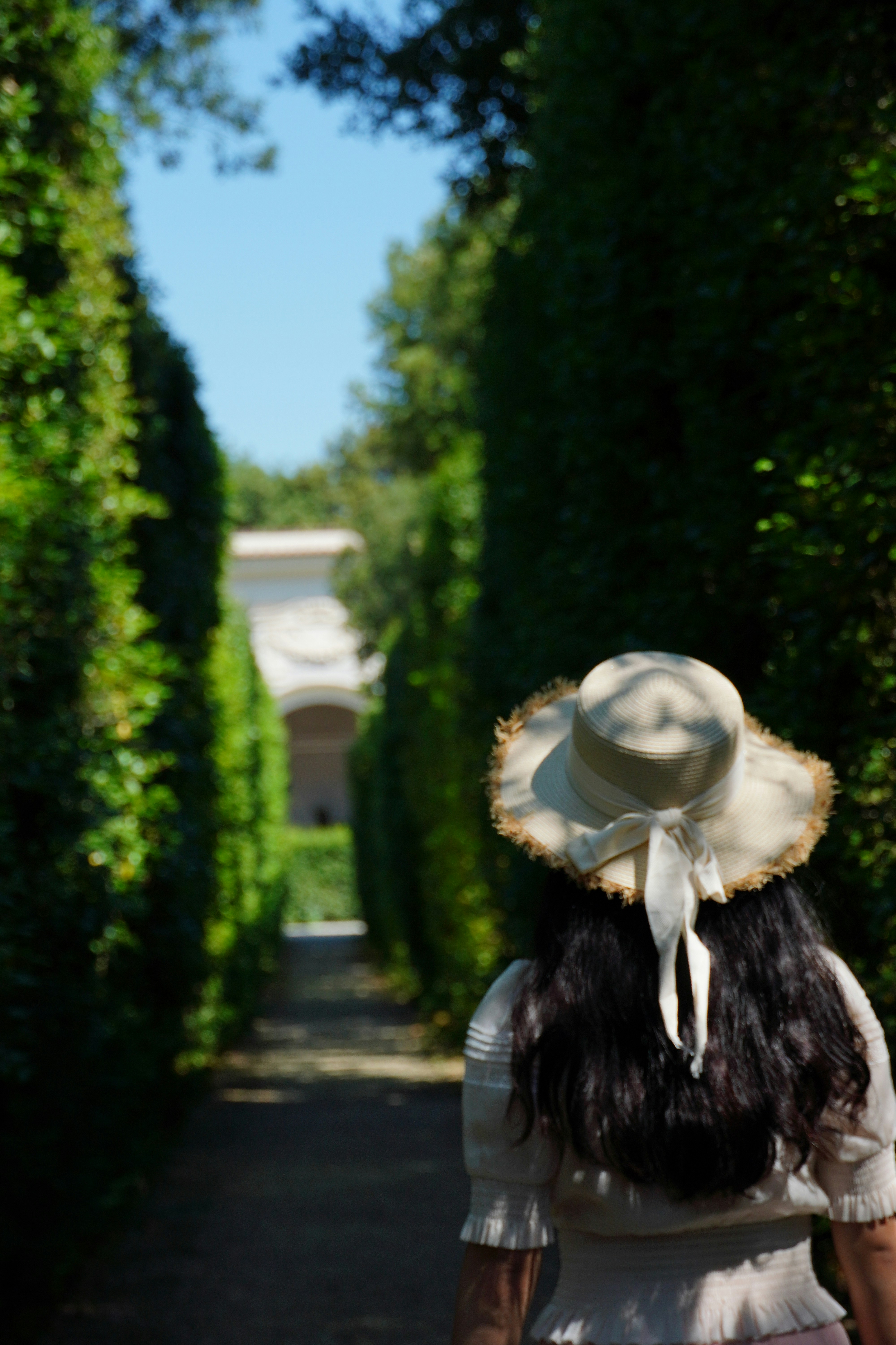 Tuscan garden path with woman in sun hat - exploring hidden gems near Florence