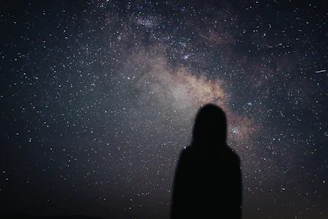 A person looking up at the stars in the night sky