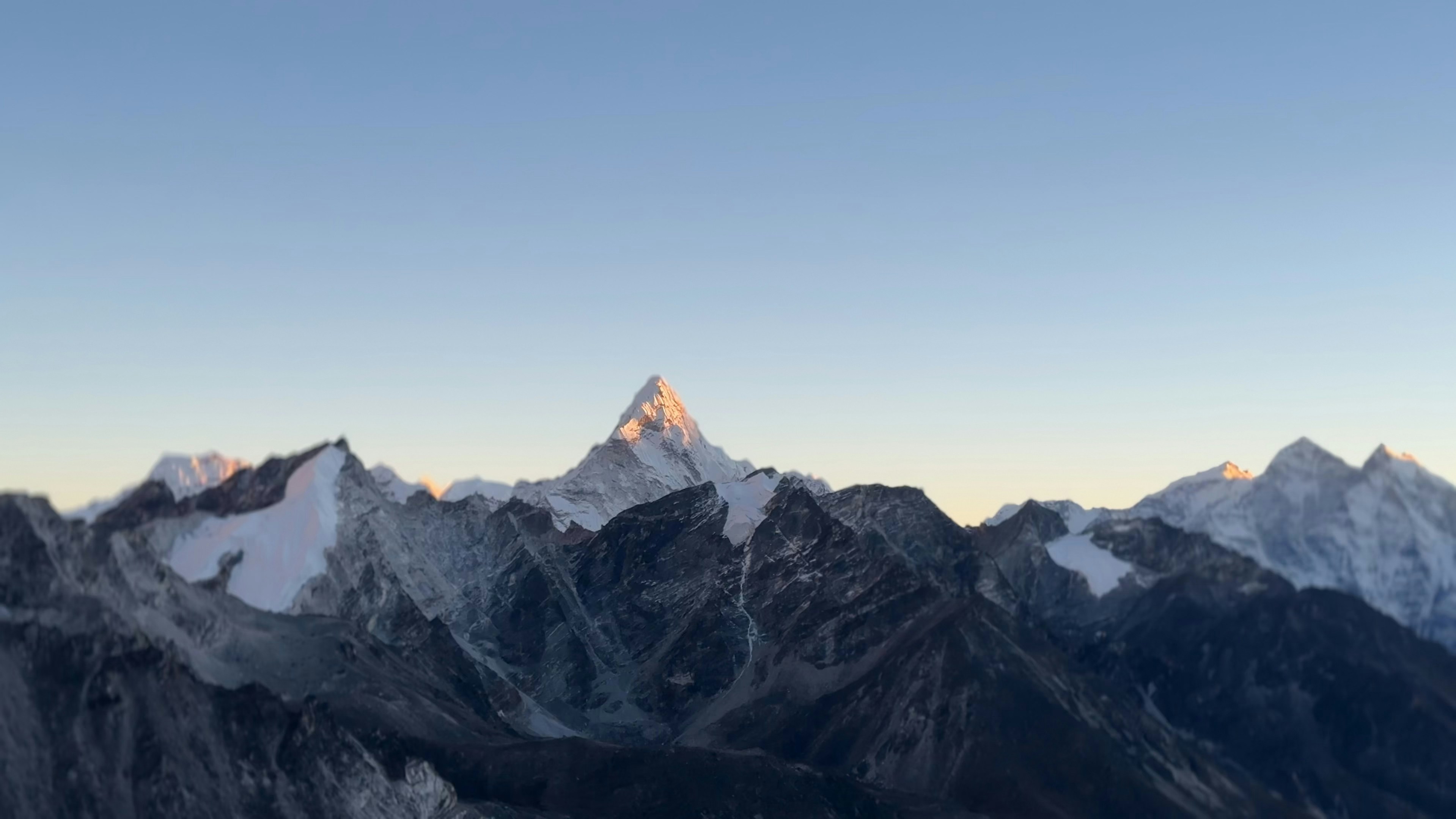 A mountain range with snow capped mountains in the background