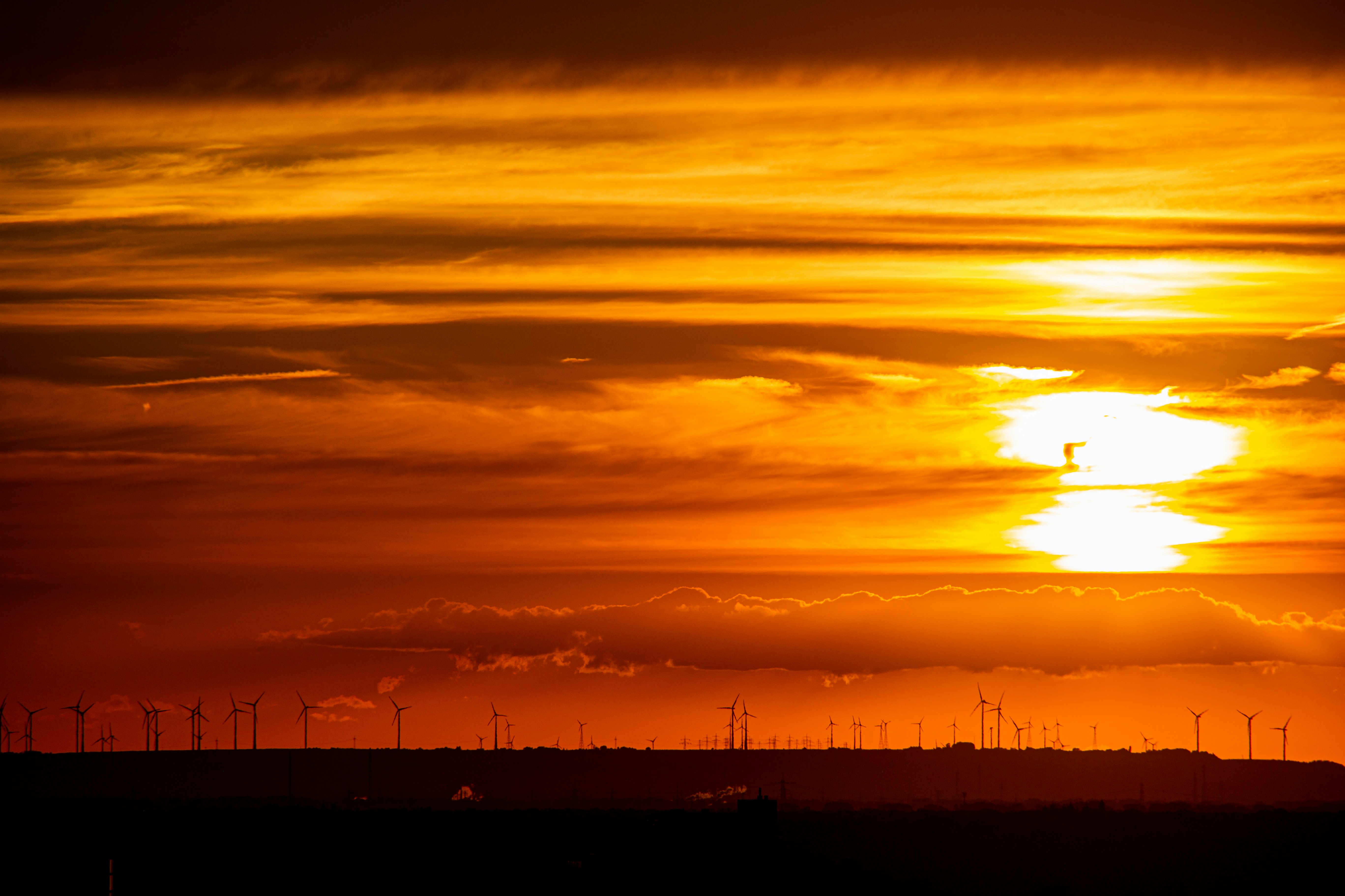 The sun is setting over the horizon of a field