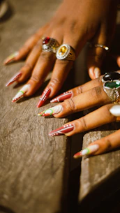 A close up of a person's hands with rings on them